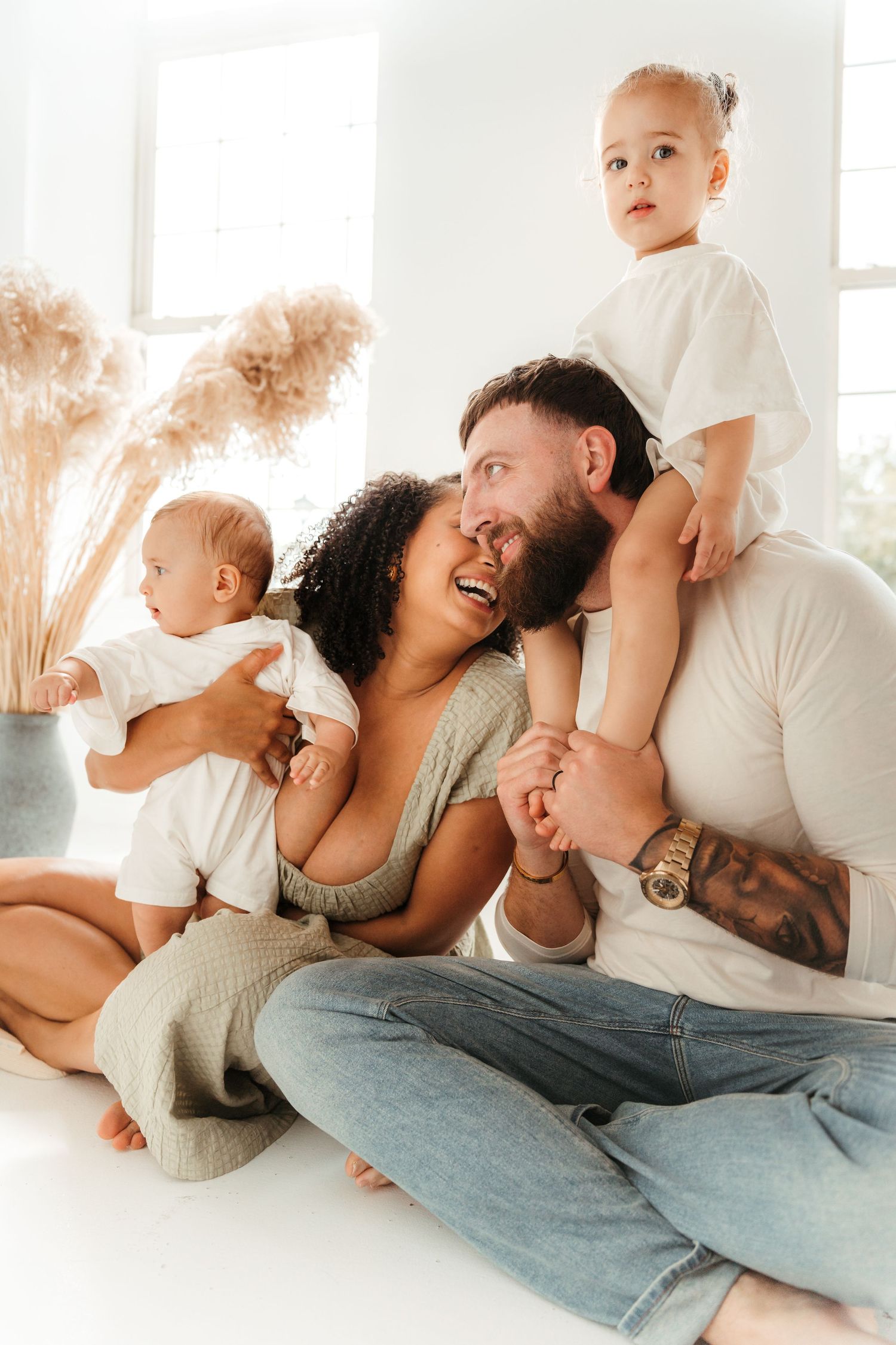 Family of four laughing and playing during an indoor studio family session in Charlotte, NC.