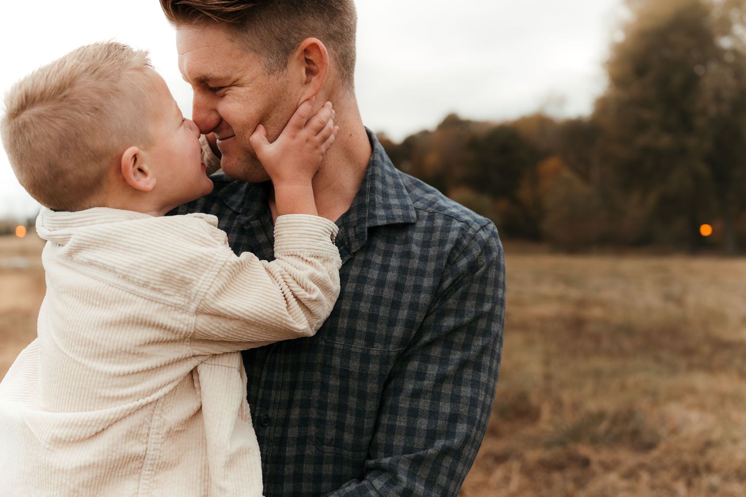 Father hugging son outdoors in Fort Mill, SC lifestyle family session.