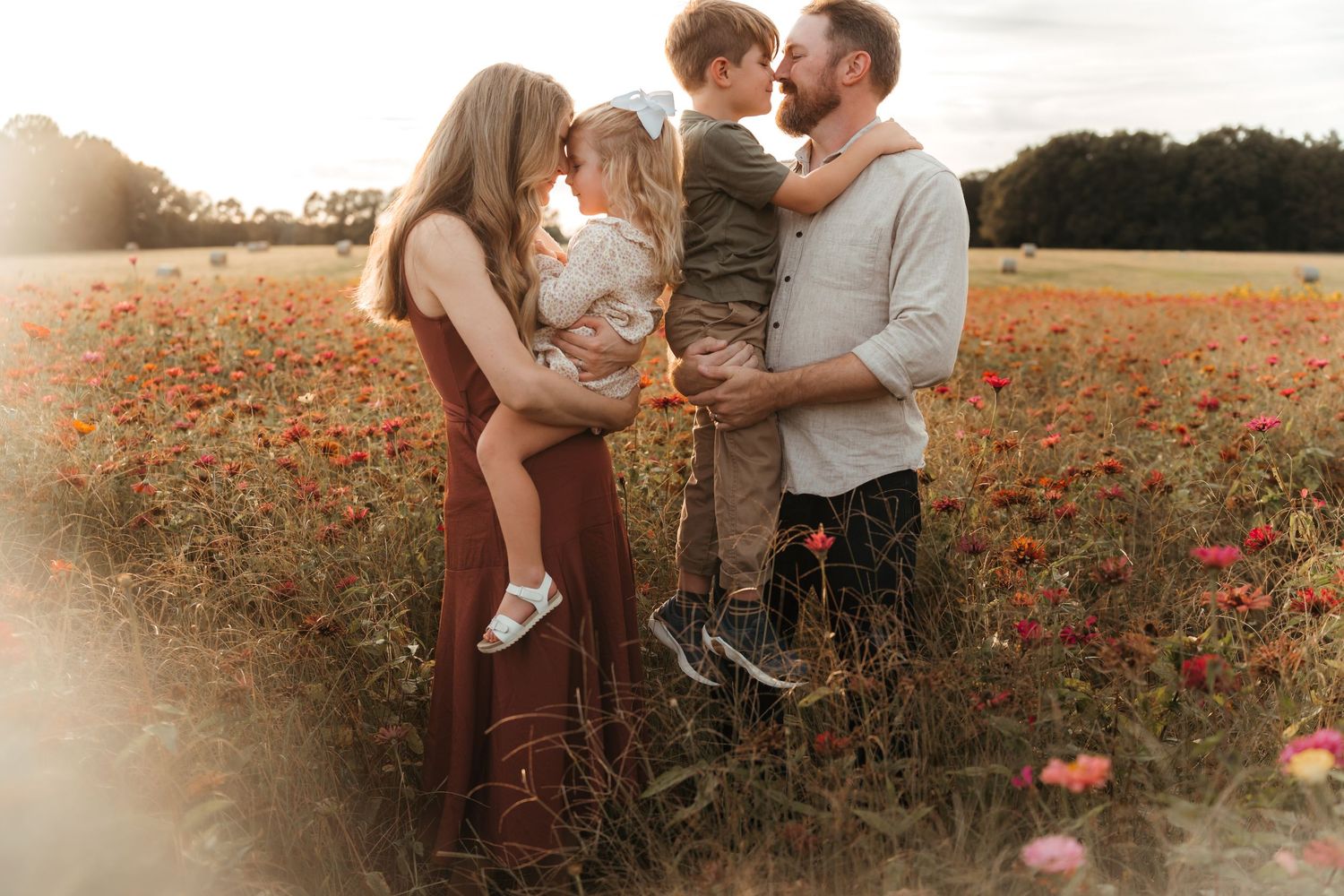Family snuggling in the middle of a zinnia field during this outdoor lifestyle family session near Charlotte, NC.
