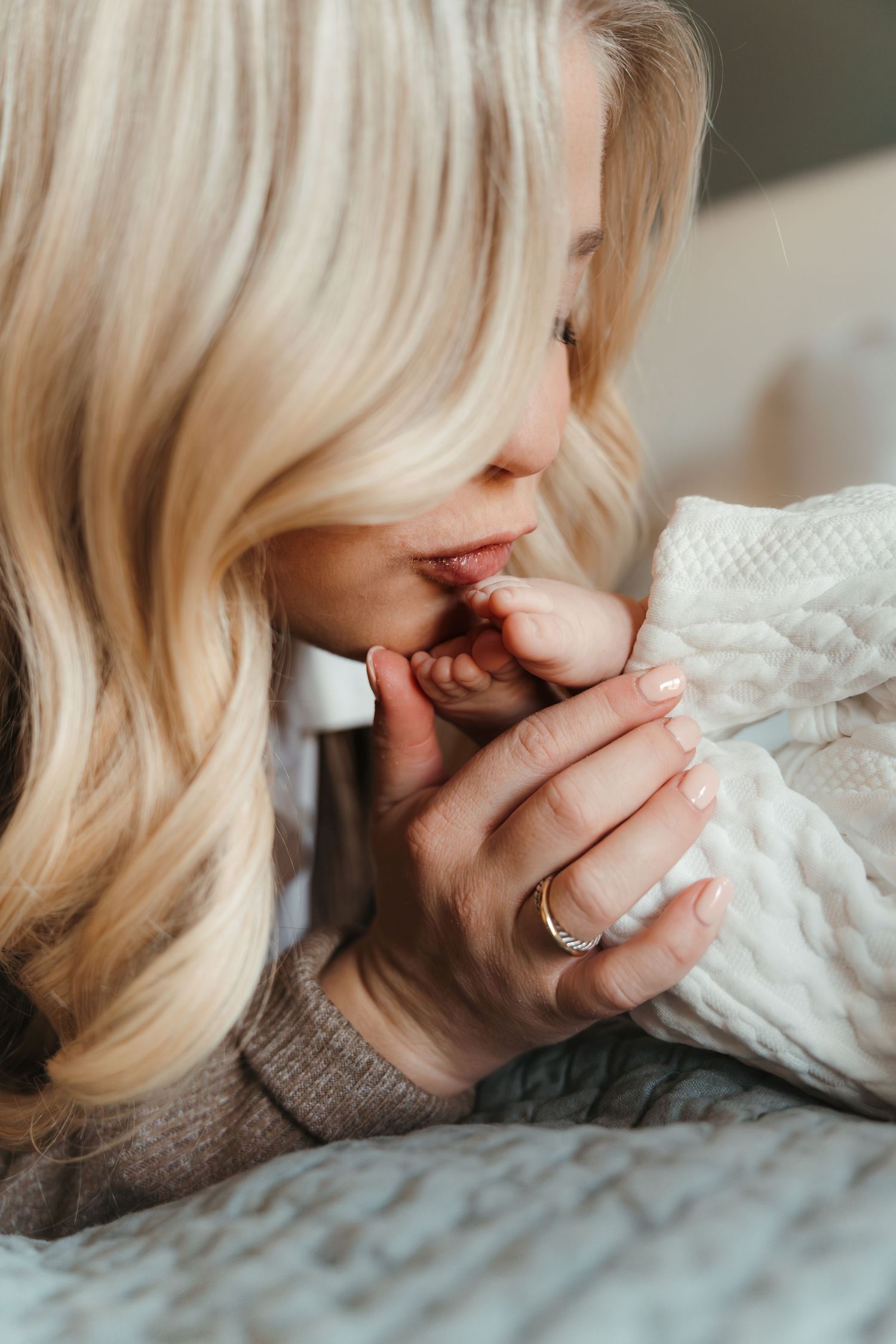Mother kissing newborn toes during a lifestyle newborn session in Charlotte, NC.