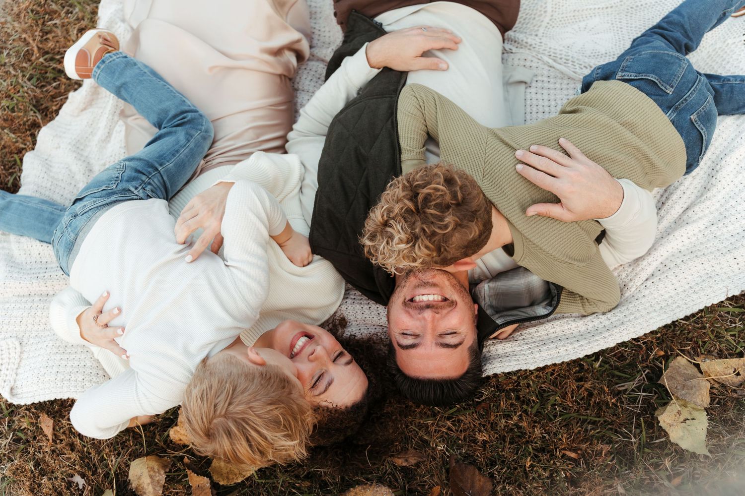 Family cuddled together on a blanket during a Charlotte, NC outdoor session.