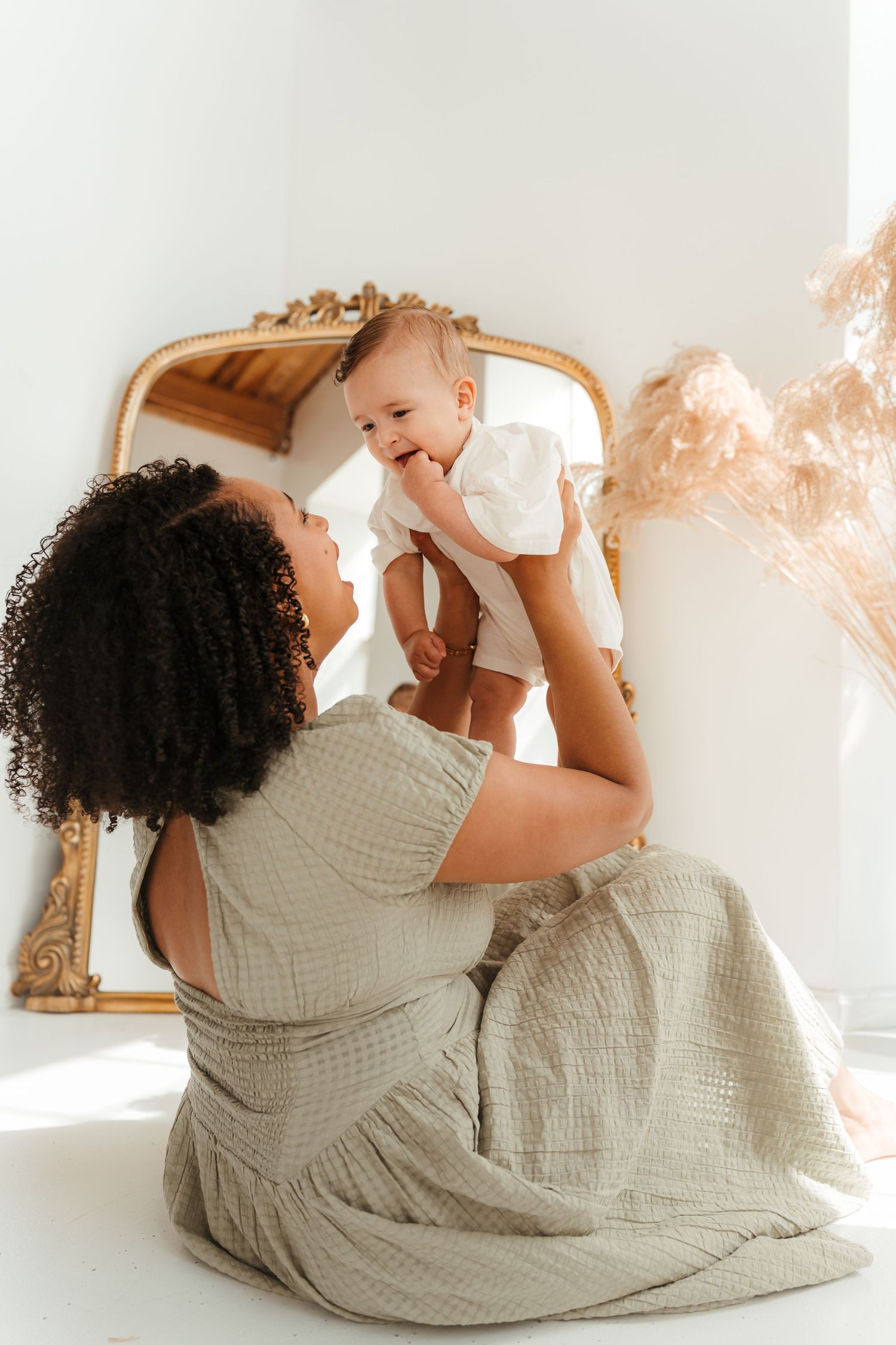 Mom lifting son into the air during an indoor studio family session in Charlotte, NC.
