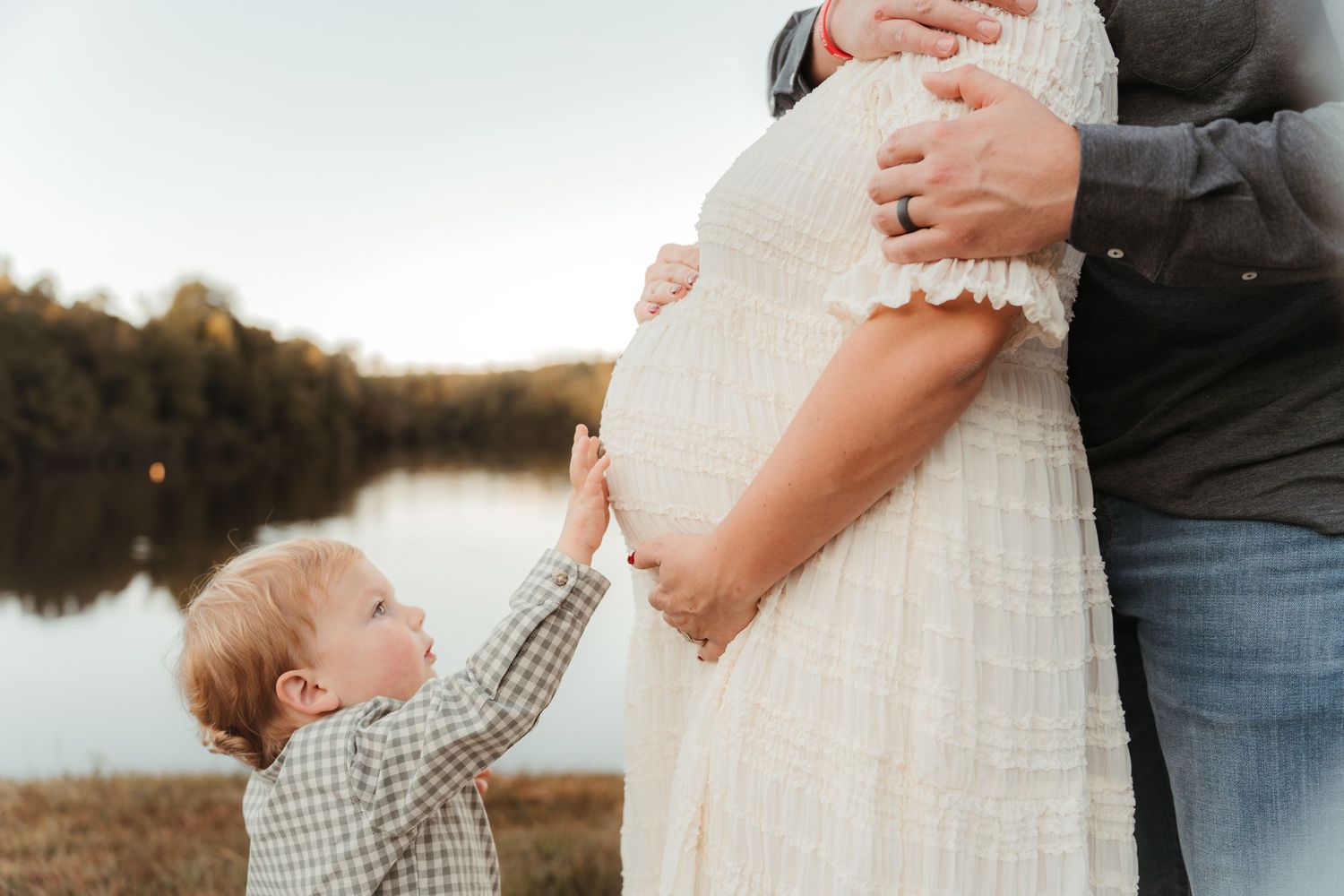 Pregnant mother standing in golden sunlight in an outdoor Charlotte, NC maternity session.
