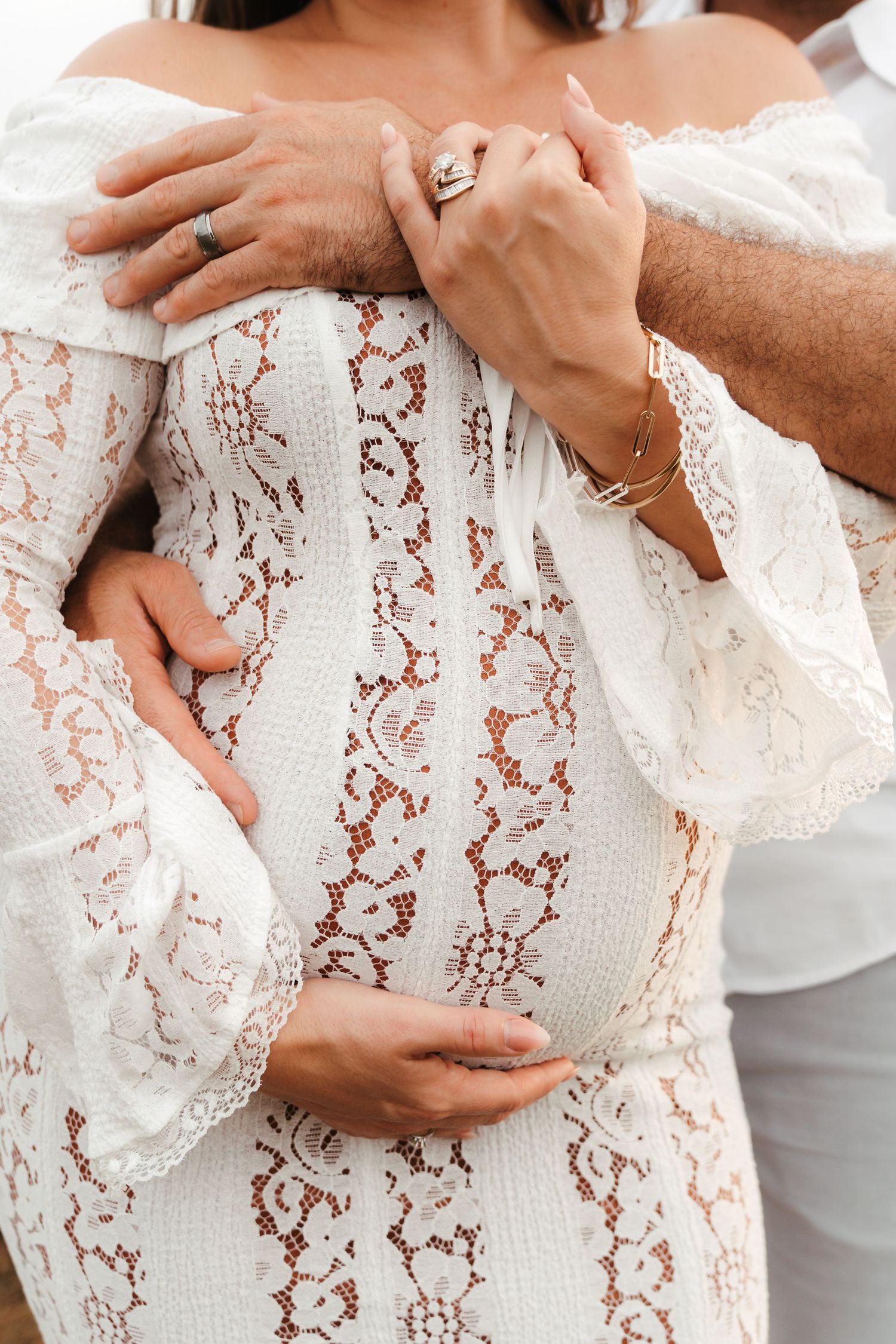 Mother and father holding belly in soft natural light during an outdoor maternity session in Charlotte, NC.