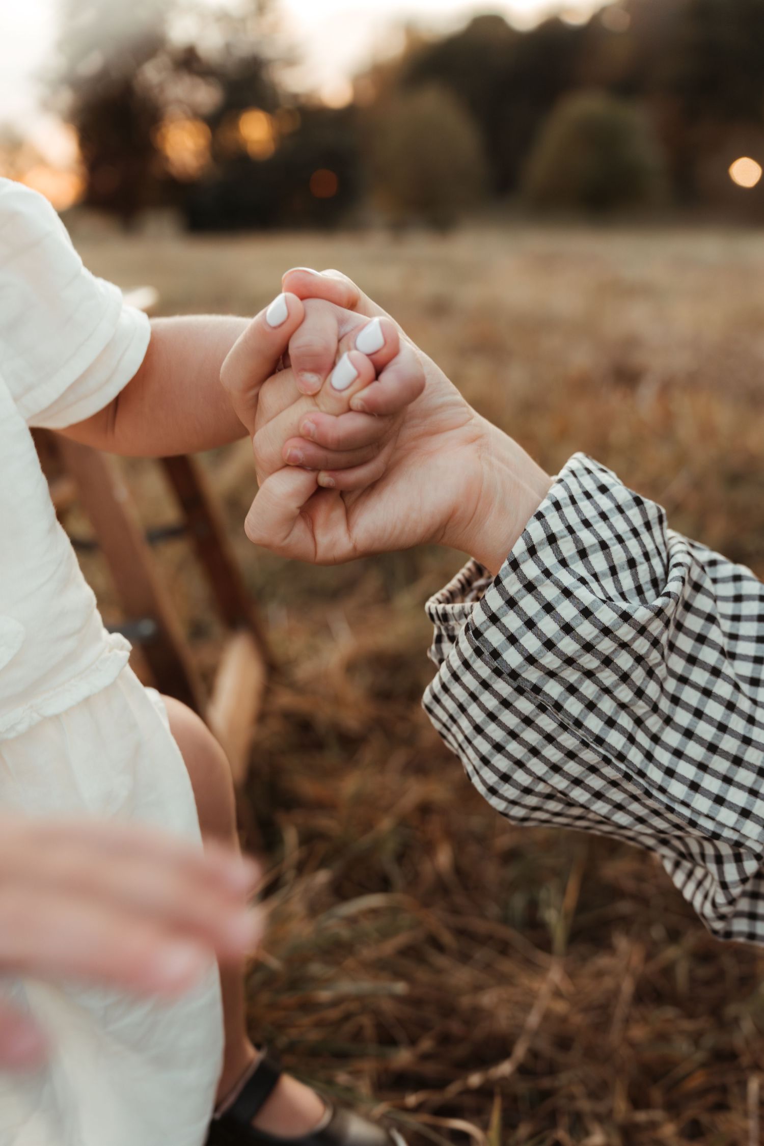 Little girl holding mama's hand tightly during a golden hour family photo session in Fort Mill, SC.