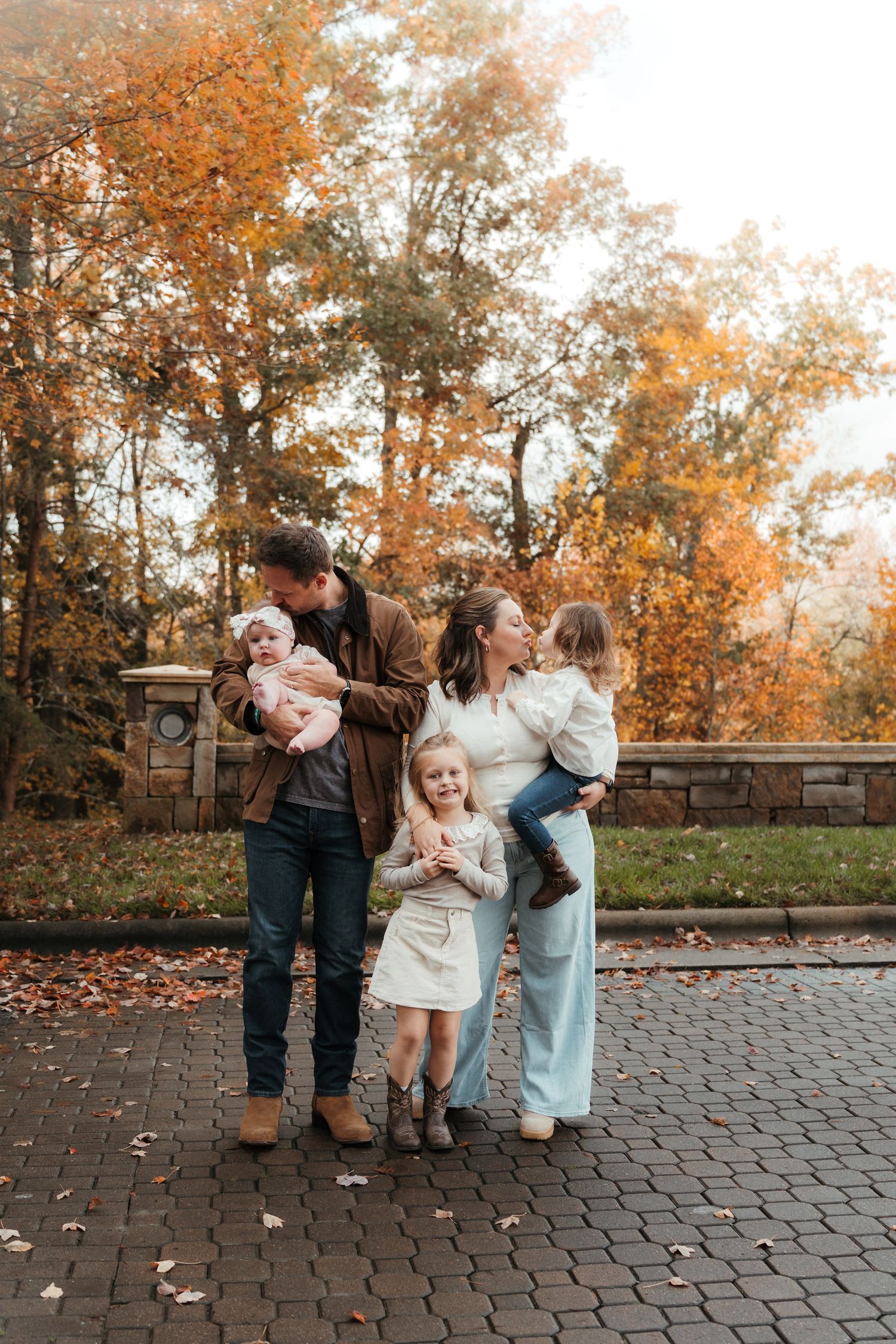Charlotte, NC photographer wrapped up with her three children and husband on a beautiful stone bridge.