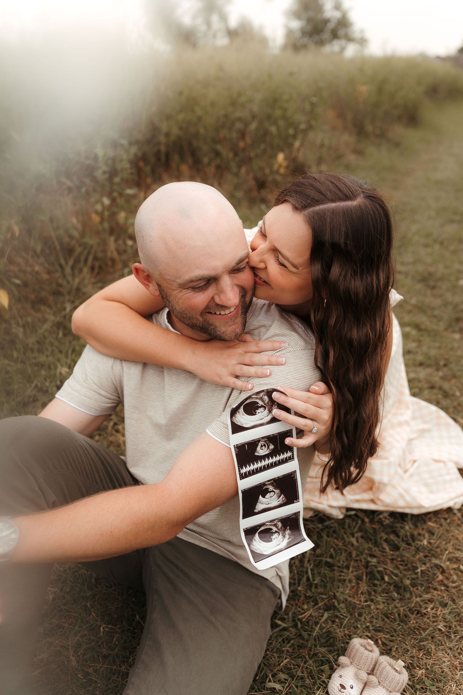 Expecting parents laughing together in a field during a Fort Mill, SC maternity session.