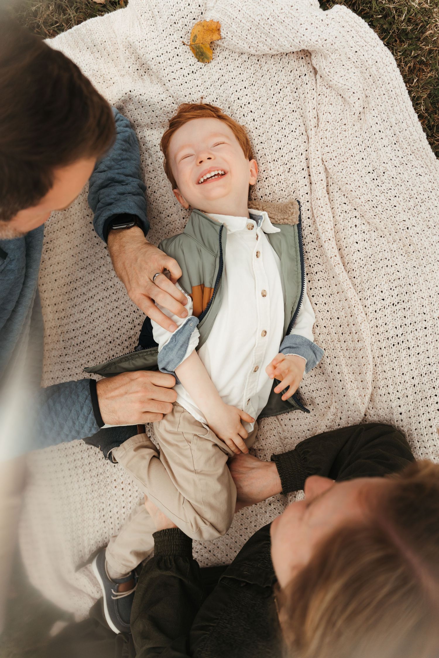 Family of three snuggled on a blanket during this lifestyle family session at Five Blossoms Farm located in Clover, SC