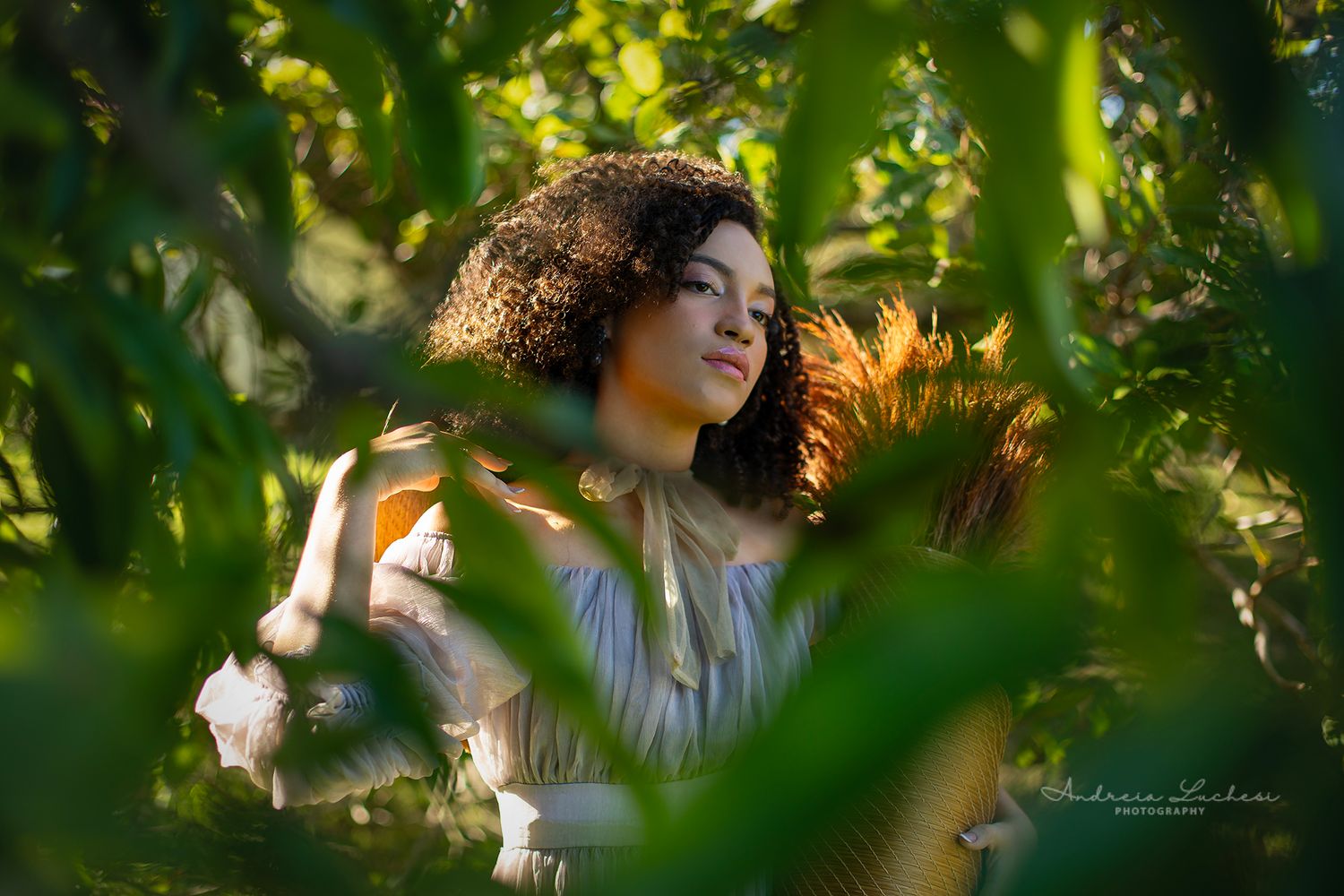 Outdoor portrait of a woman surrounded by natural light and greenery