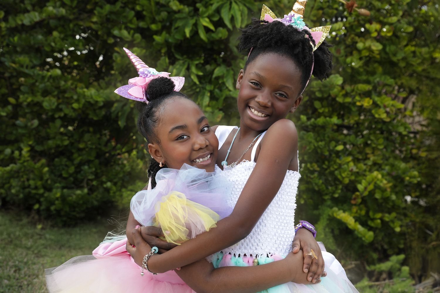 Two children hugging during a colorful outdoor birthday photography session