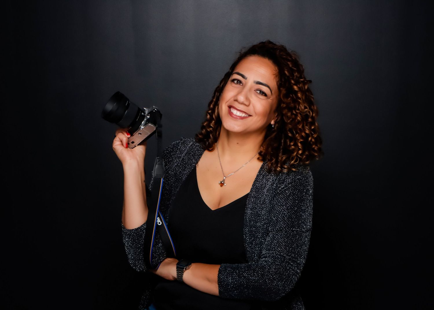 Professional photographer holding a camera during a studio portrait session