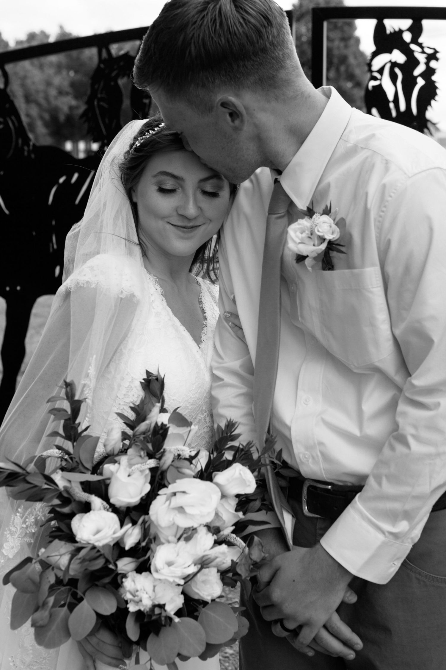 Close-up black and white wedding portraits featuring elegant white rose bouquet.