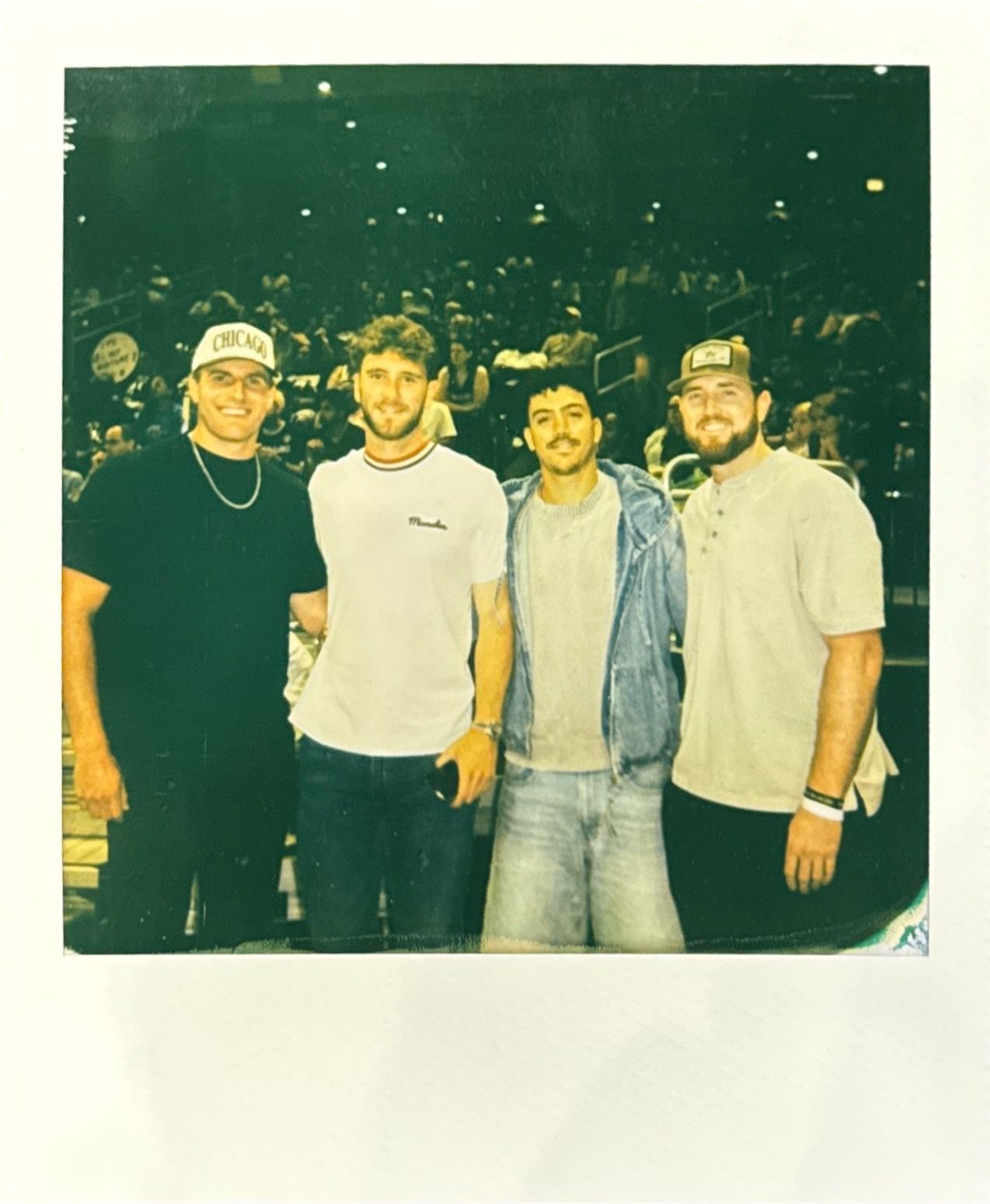Group of friends posing together in casual clothing at night.