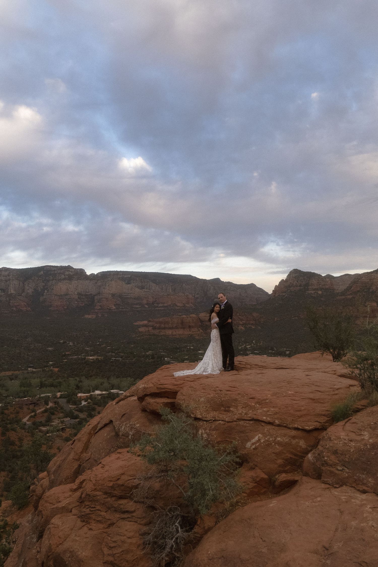 a couple stands on the edge of a canyon in Arizona and stares into each others eyes.