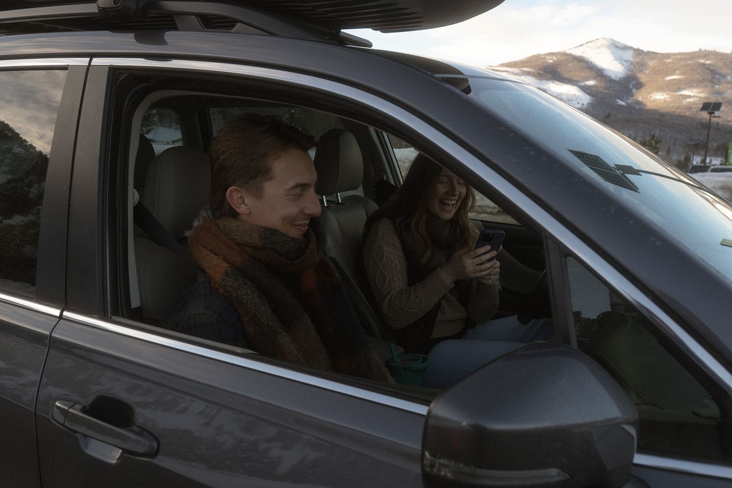 a couple driving in their suburu laughing with each other