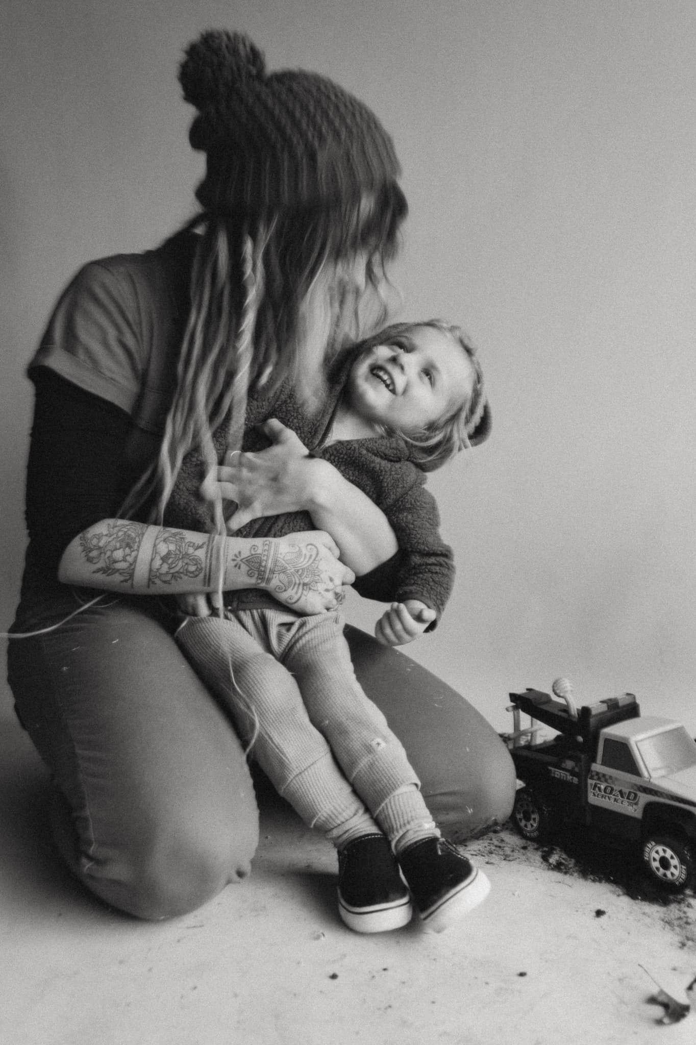 Tris Ambrey, Photographer and owner of Beautiful Chaos Photography Headshot, a mother with her son, tonka trucks, dirt