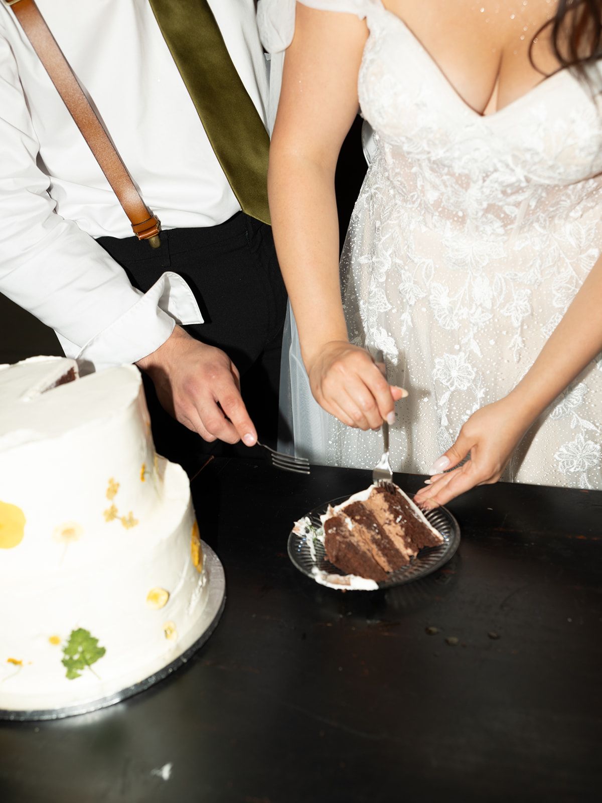 flash photography of cake cutting for couple, close up of hands, cake, table