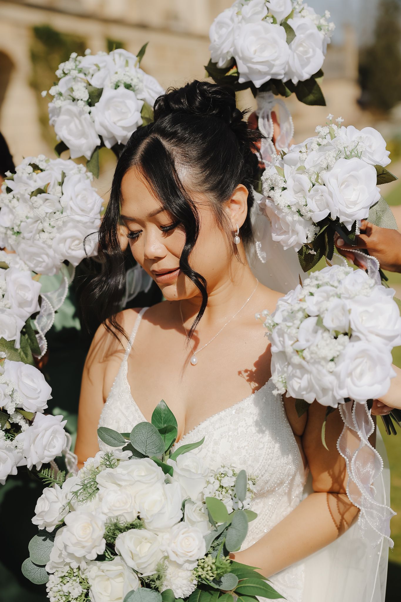 Close-up of bridal bouquet featuring white roses and hydrangeas with delicate greenery.