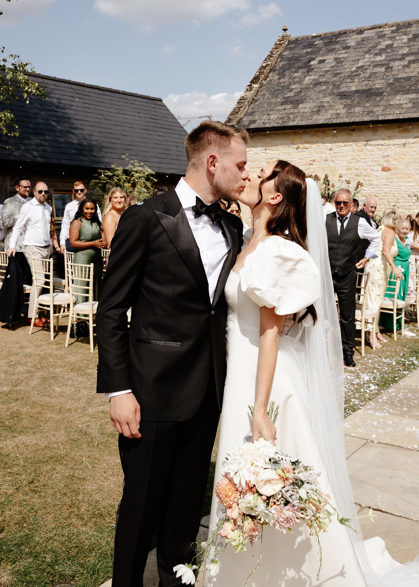 A romantic wedding photo sequence showing a couple sharing tender moments outside a rustic stone building.