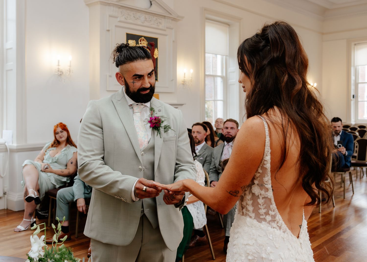 Couple shares their first dance in a bright reception hall with classic architectural details.