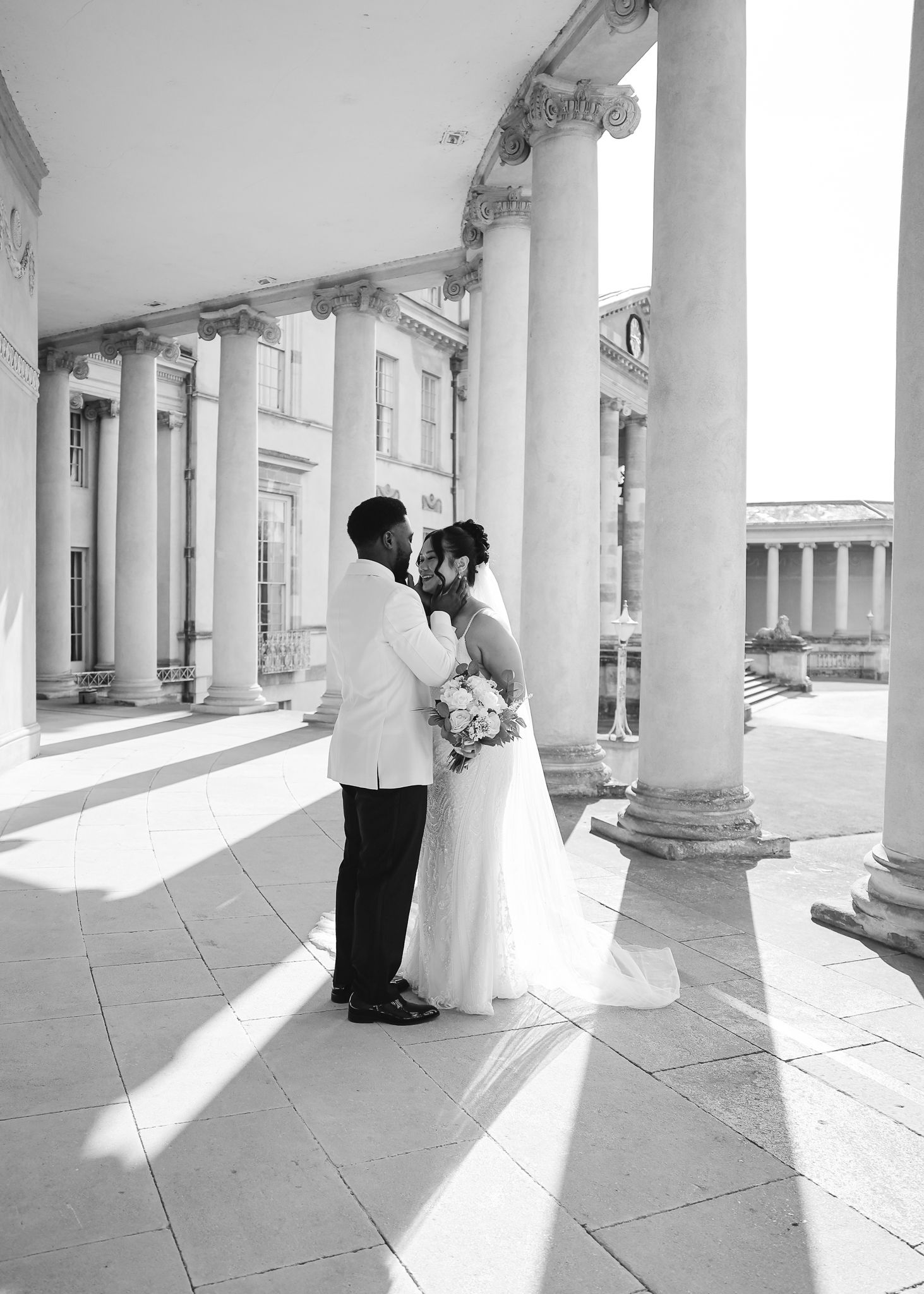 A series of black and white photos showing a couple in a columned walkway during a wedding photoshoot.