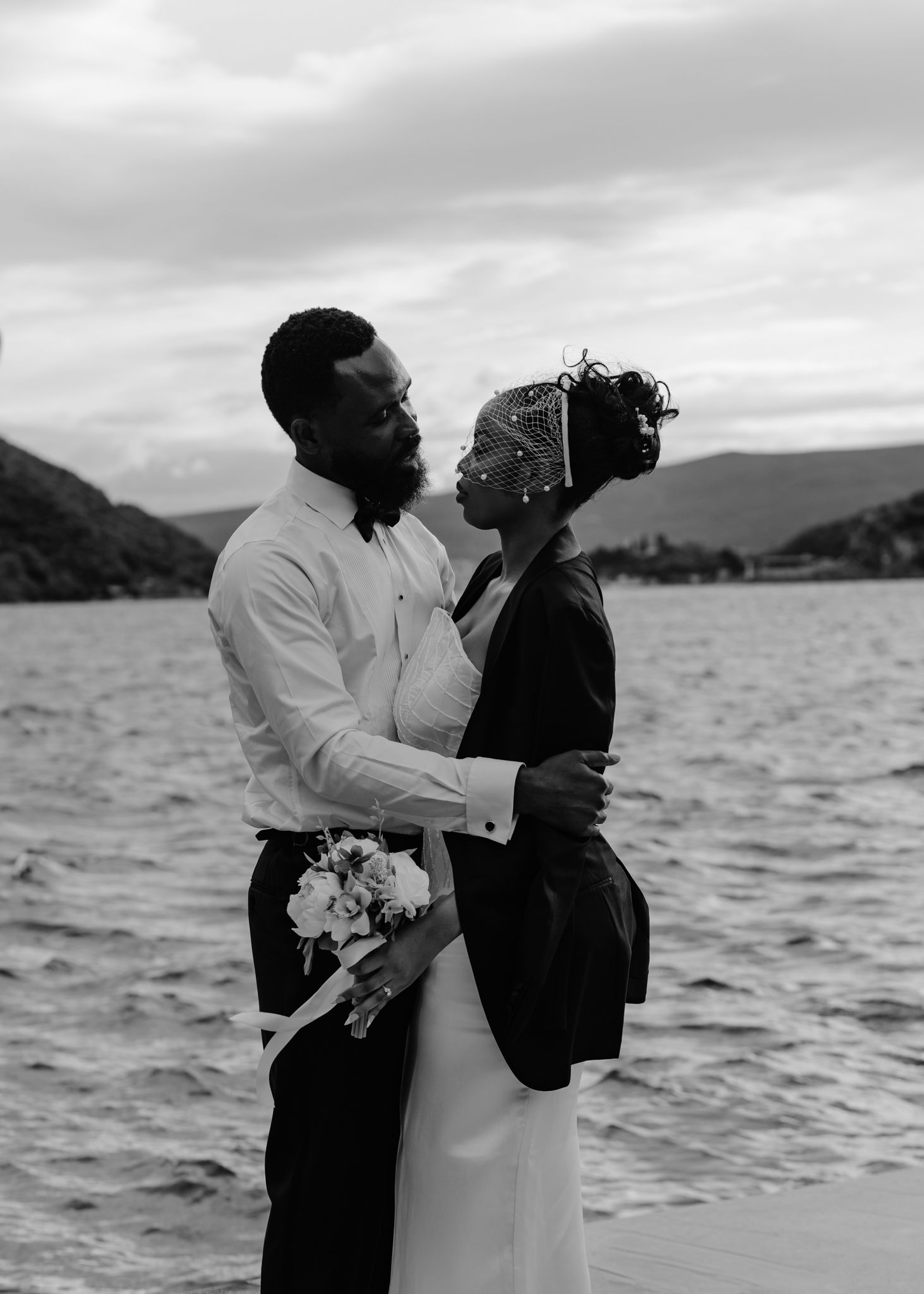 Black and white photos capture romantic moments between a couple by the ocean.