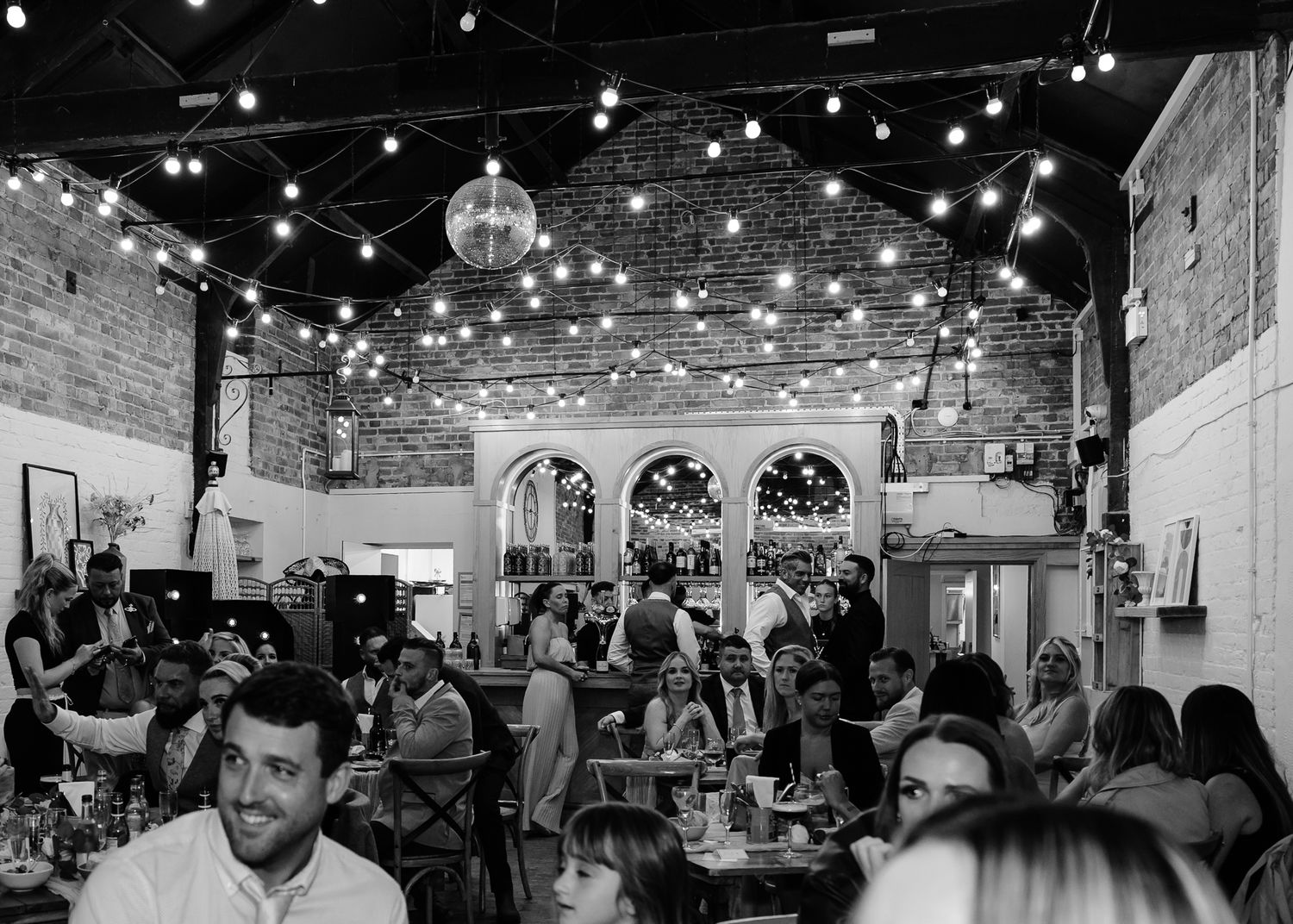 A crowded indoor event space filled with people mingling and networking at what appears to be a business gathering.