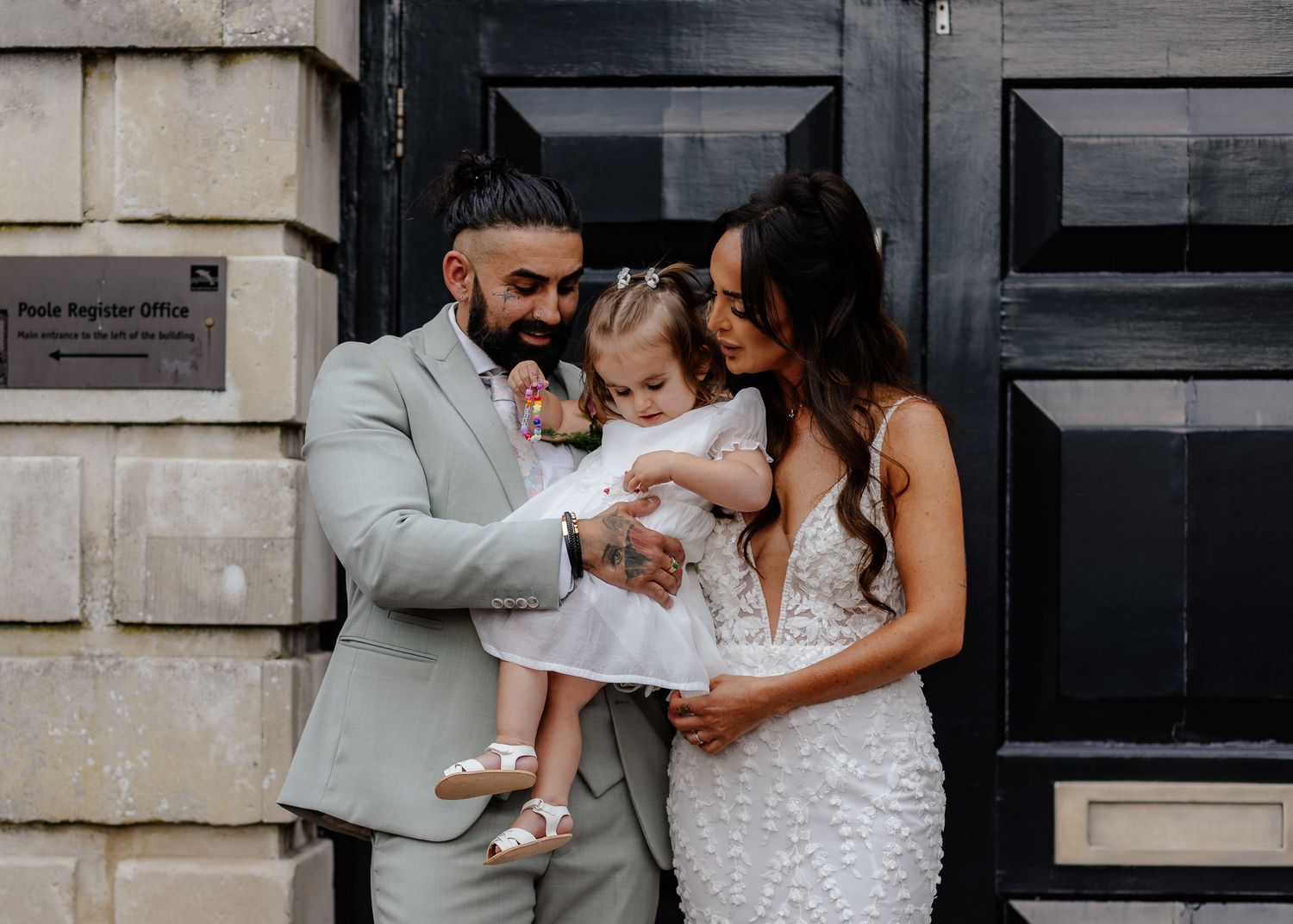 A tender family moment outside a stone building as they share an intimate embrace.