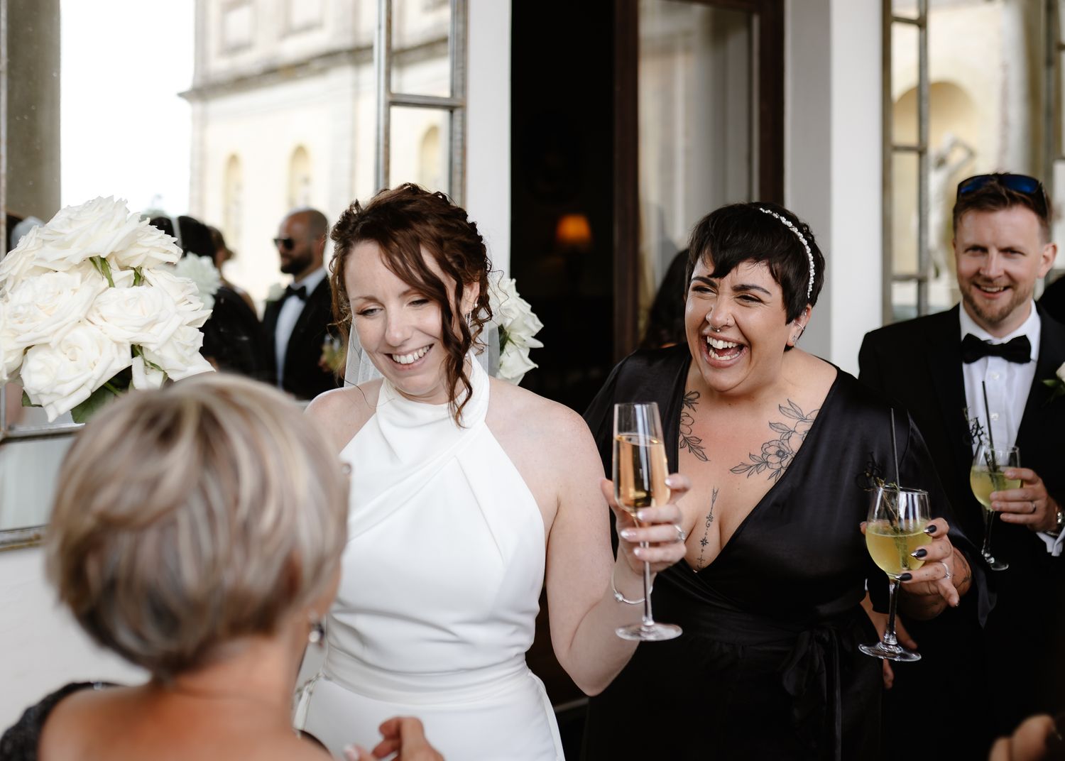 Wedding guests enjoying drinks and conversation at an elegant indoor reception.