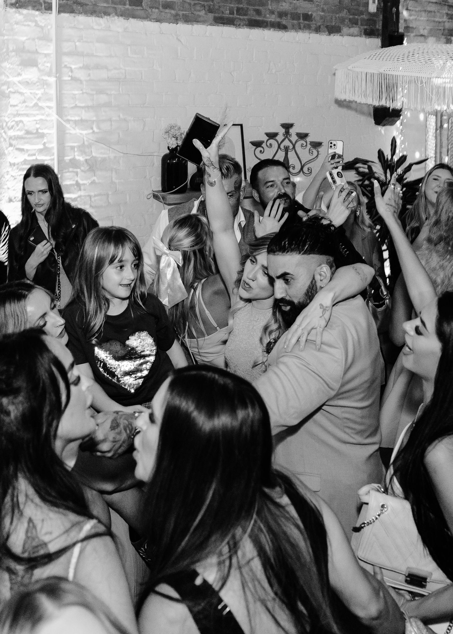 Black and white photo of people dancing and having fun at a crowded party or nightclub event.