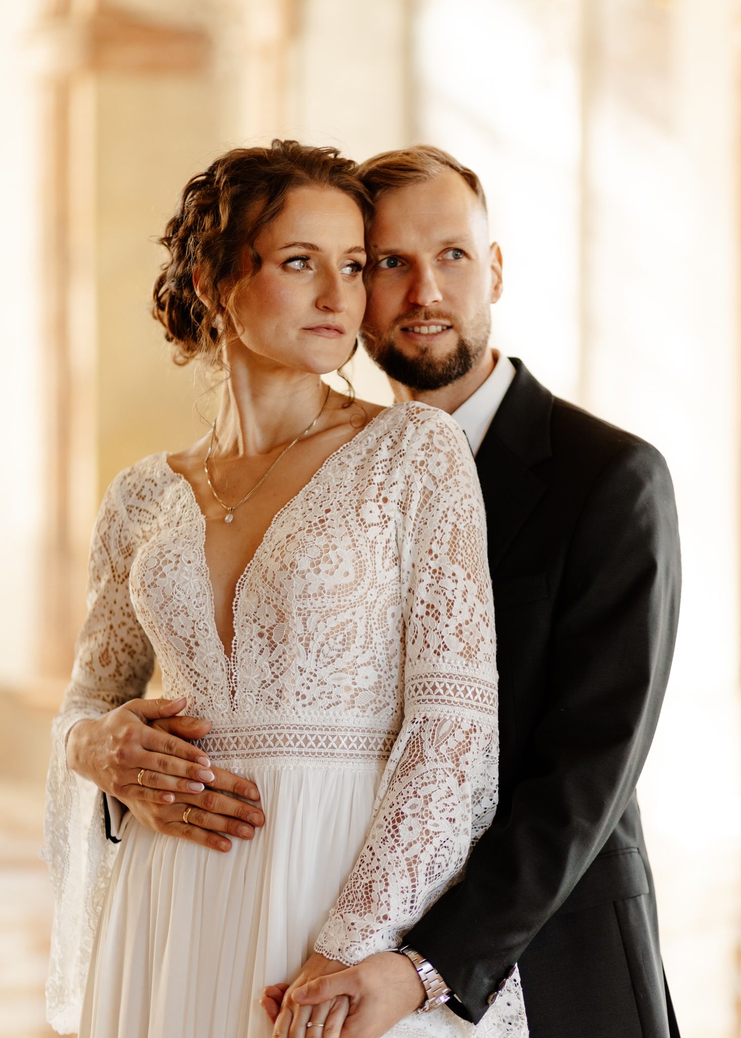 Intimate wedding portraits captured in a sunlit corridor with soft, warm tones.