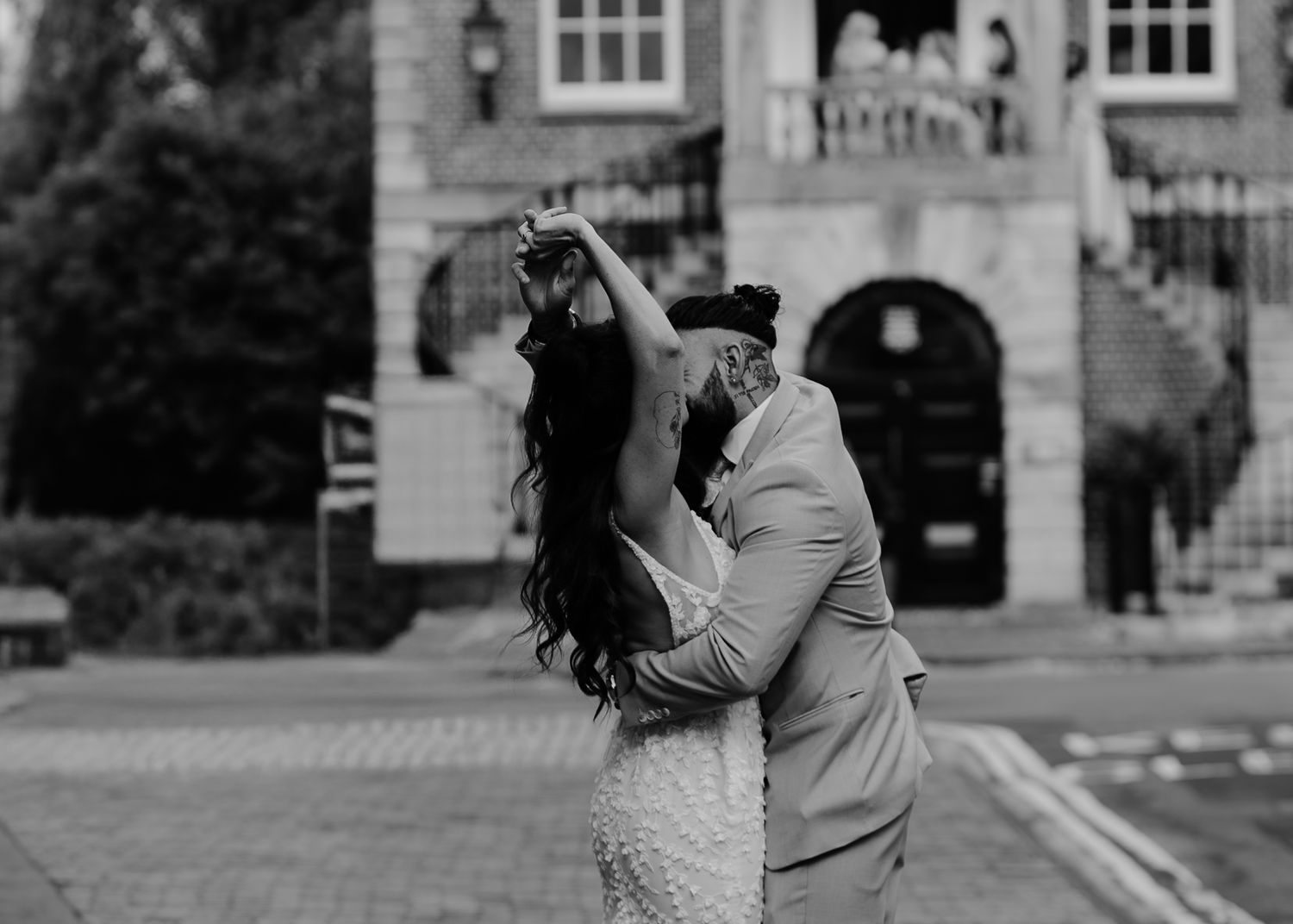 A couple dancing together on a cobblestone street, twirling in romantic embrace.