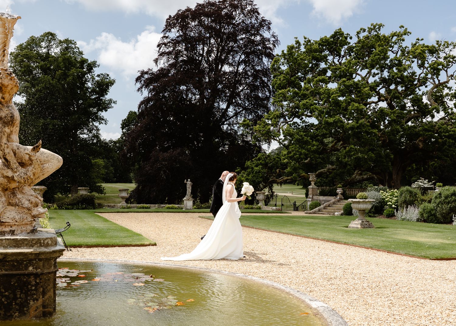 Panoramic view of an elegant estate garden with stone pathways and manicured landscaping.