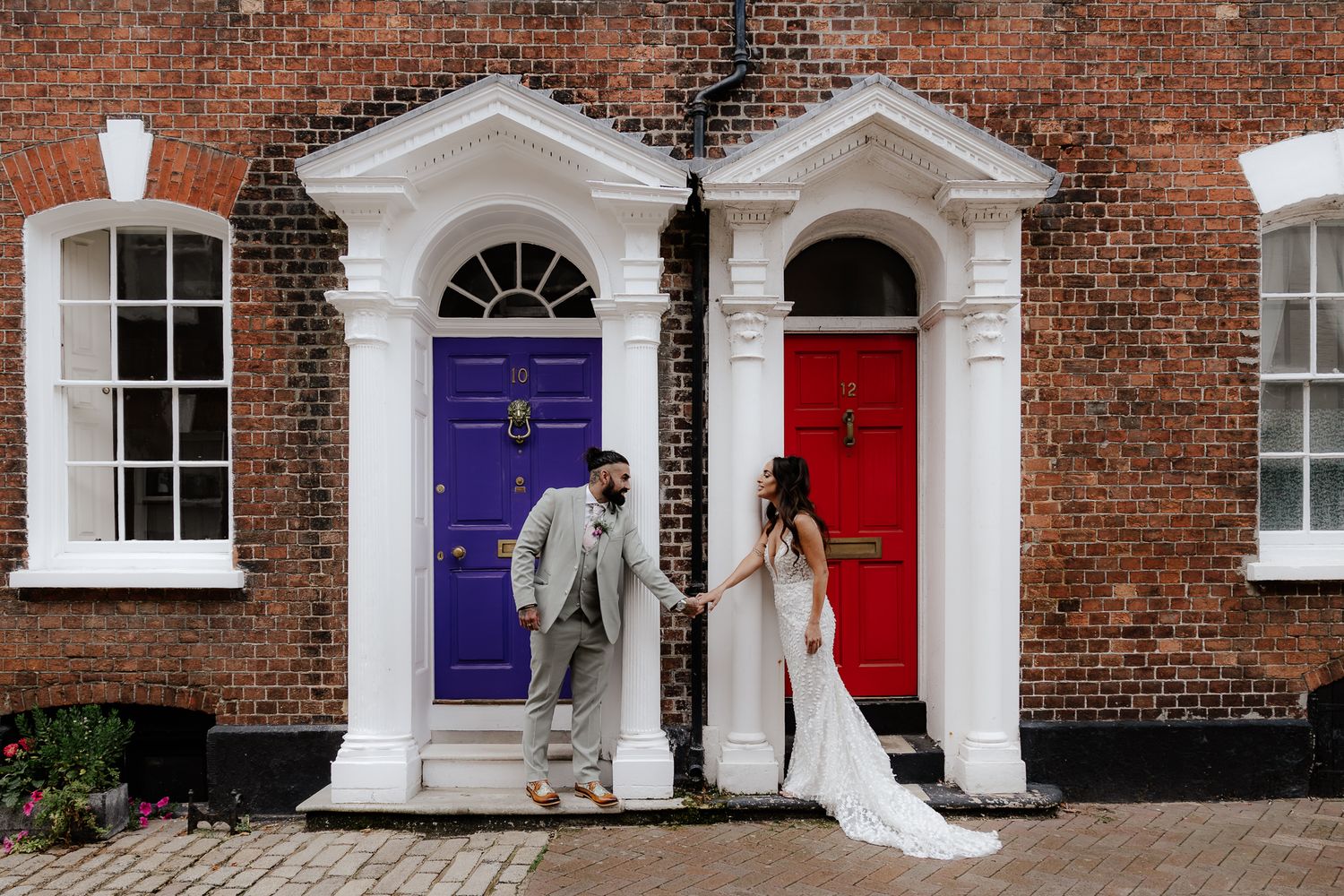 A row of colorful Georgian doors with white doorframes on a red brick building in Dublin, Ireland.