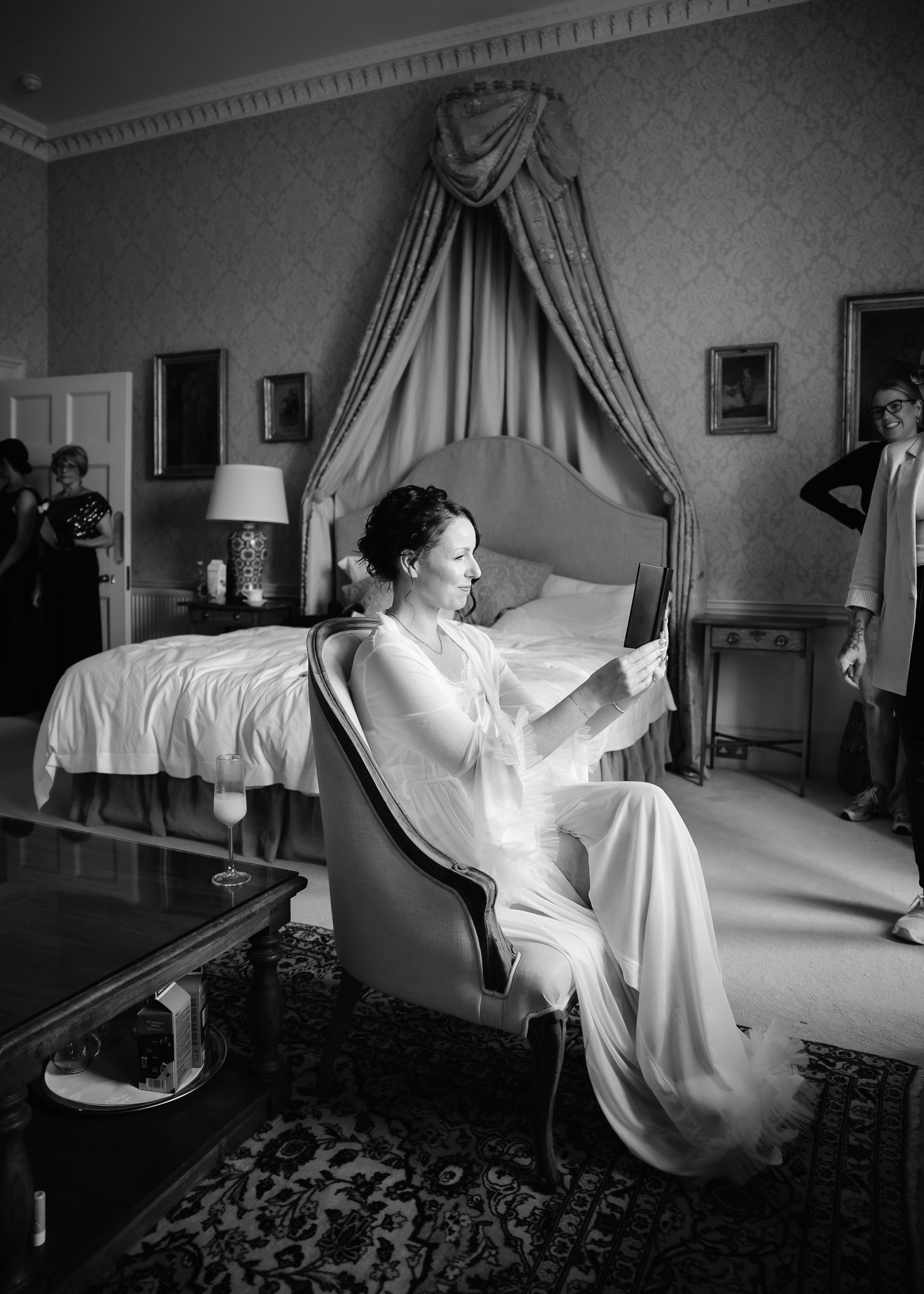 Black and white photos showing someone in a white dress posing dramatically on a bed.