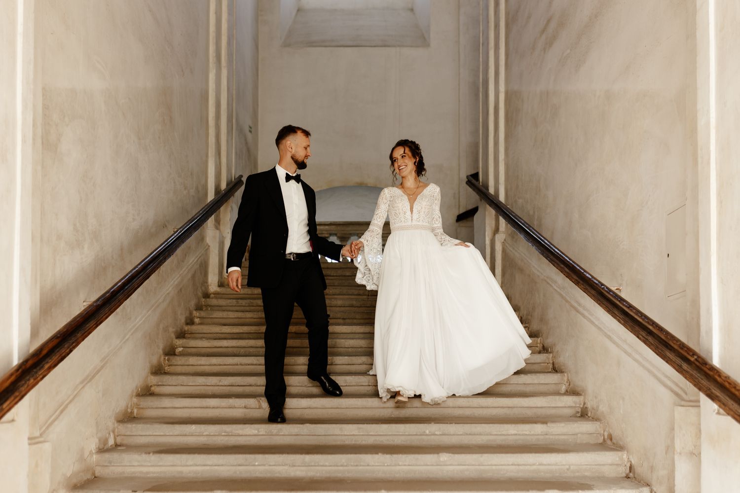Wedding photography on an elegant white marble staircase in a historic building.