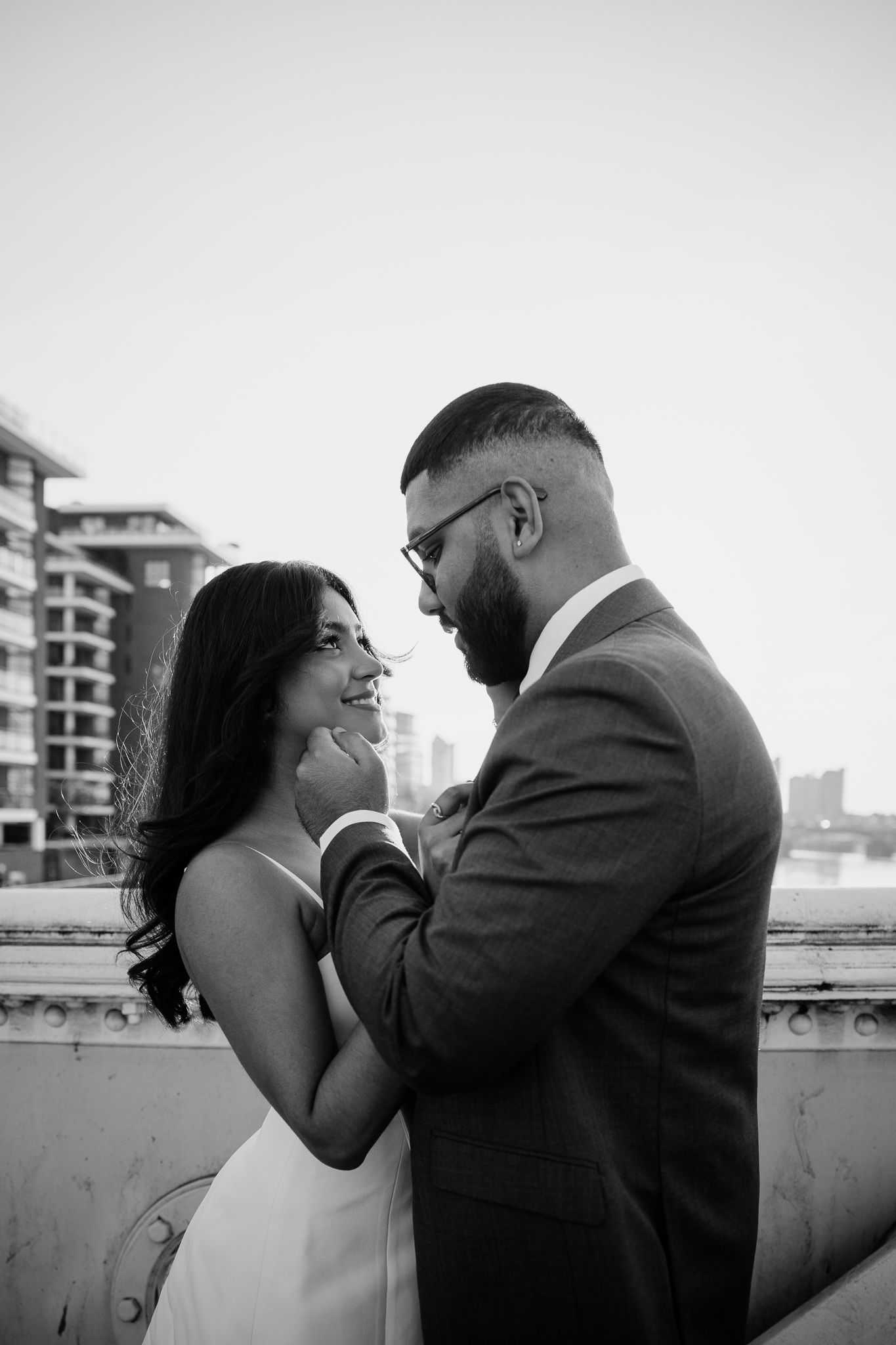 A romantic black and white photo series of a couple sharing intimate moments on a rooftop terrace.