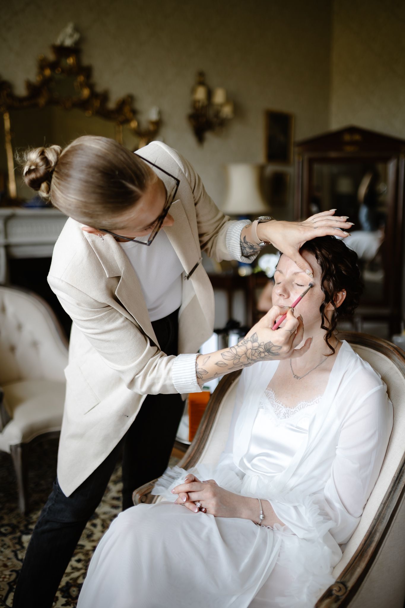 A sequence of photos showing makeup application during wedding preparations in a bridal suite.