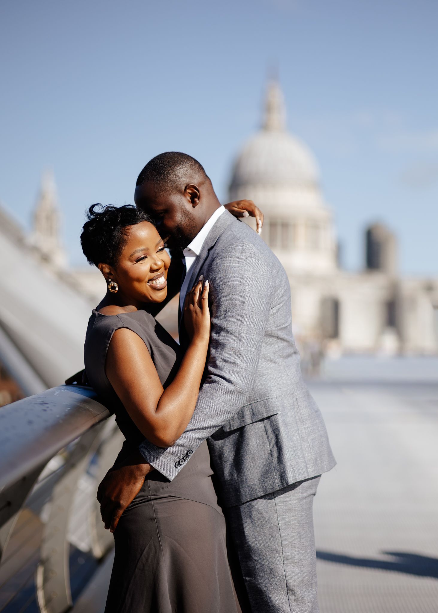 A couple shares a romantic dance together on a rooftop terrace with a domed building visible in the background.