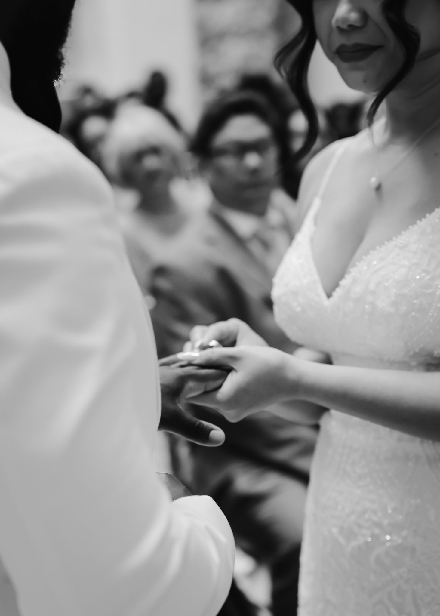 Close-up view of a bride in a white lace wedding dress at an elegant ceremony.