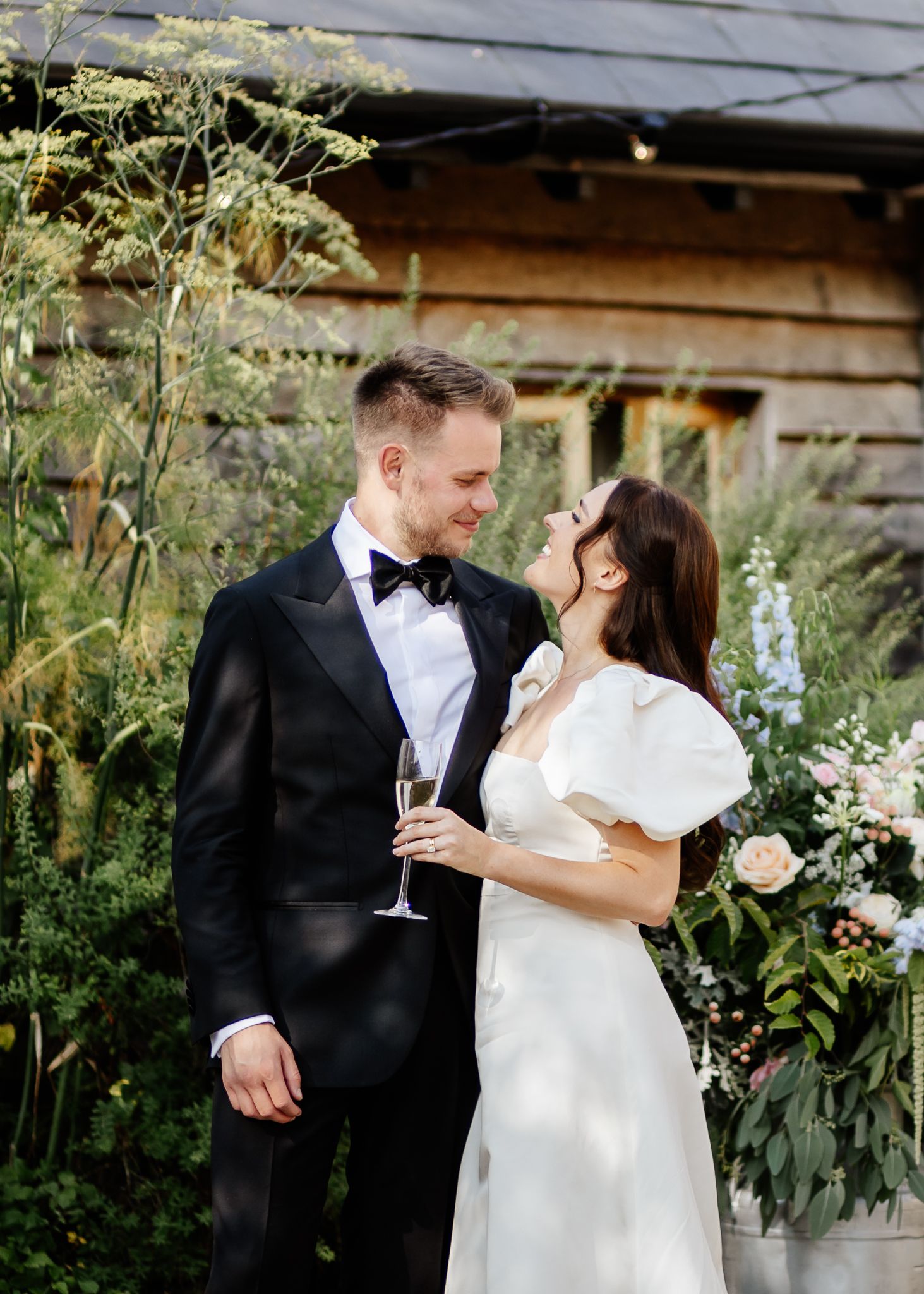 A romantic wedding photo series showing a couple embracing in a garden setting with greenery and flowers.