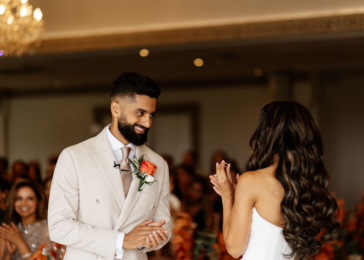 A couple shares an intimate moment during their wedding ceremony in an elegantly lit indoor venue.