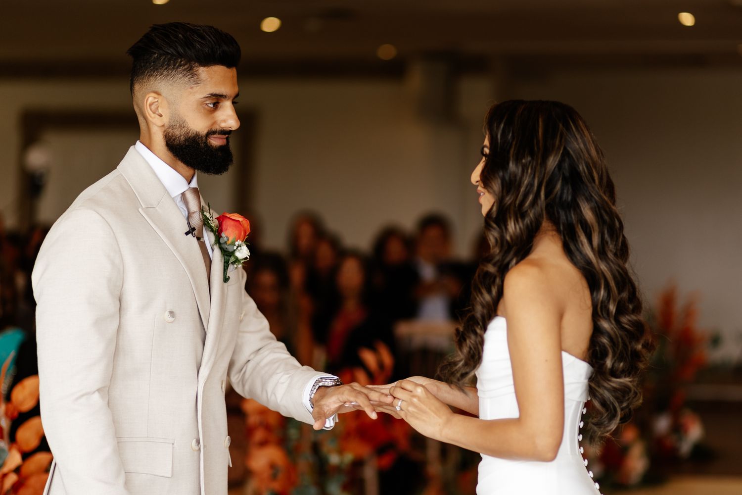 Wedding ceremony in progress with guests seated in rows watching the couple at the altar.