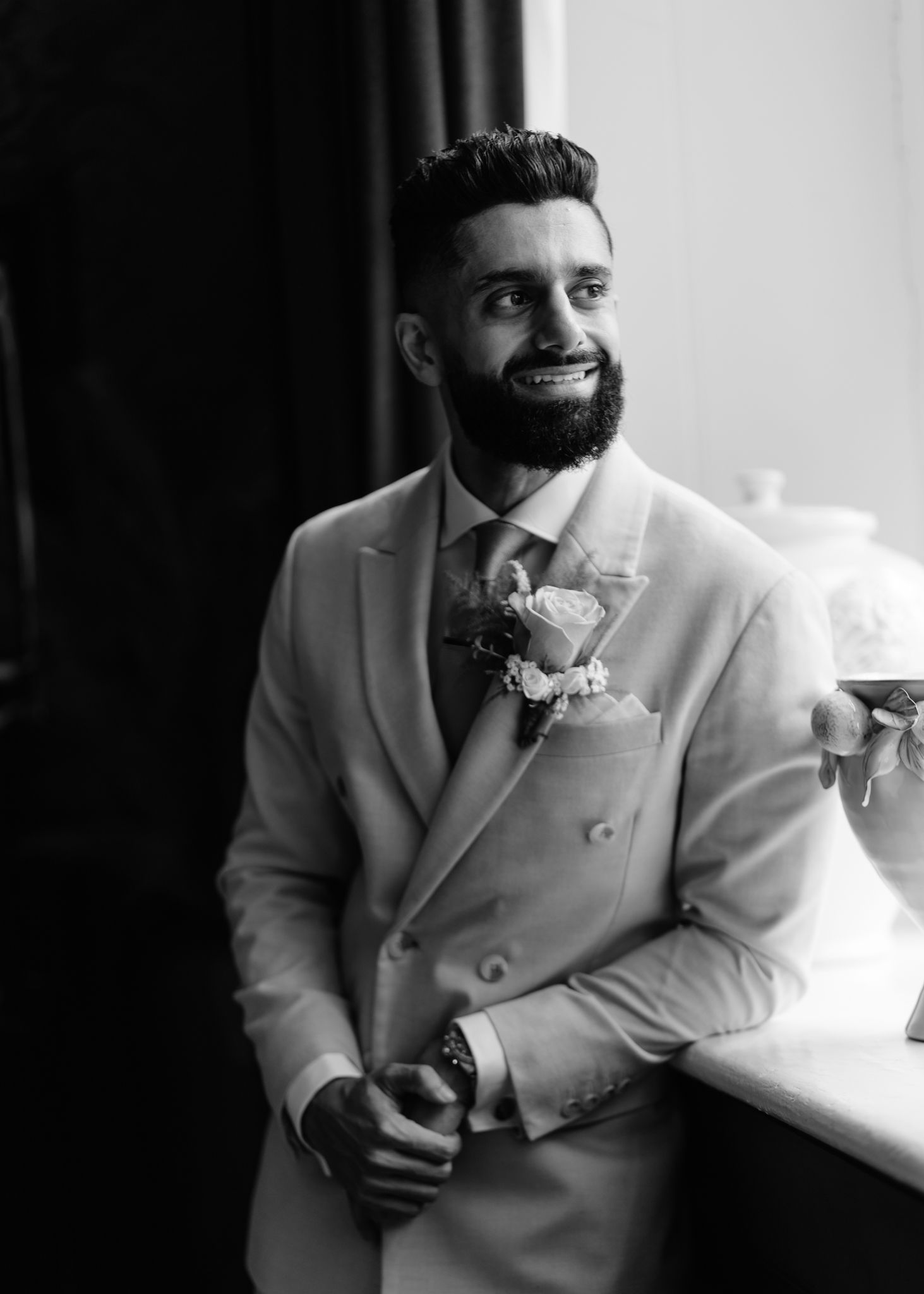 A black and white sequence of photos showing someone in a light-colored suit smoking a cigarette.
