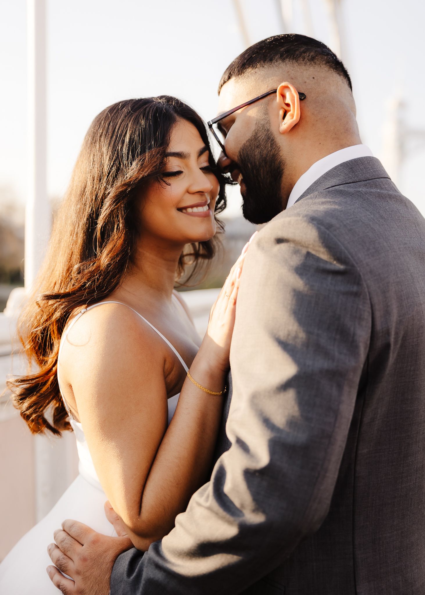 A romantic couple embraces and shares intimate moments in a series of candid photos at sunset.