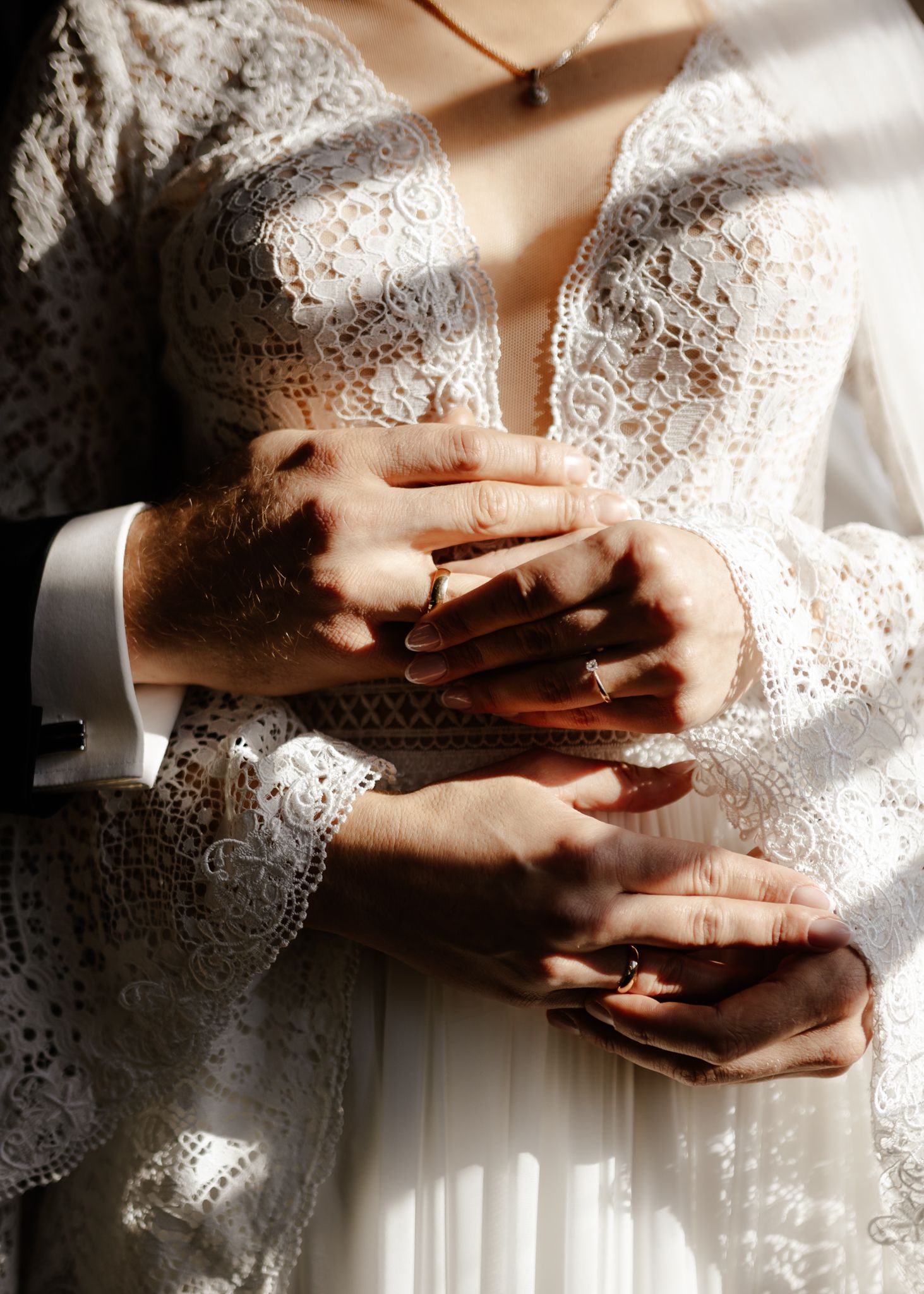 Close-up series of hands with wedding rings in delicate white lace detail.