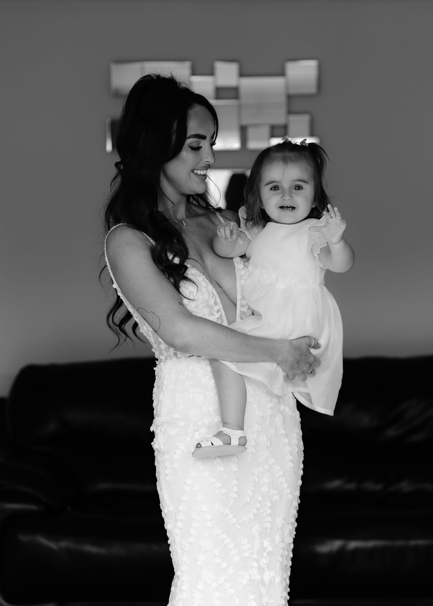 Black and white sequence of a mother and child dancing together in white dresses against a dark background.