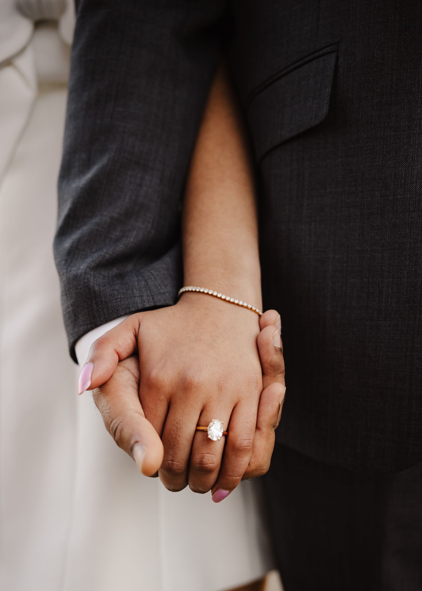 Five sequential close-up photos show hands clasped together wearing wedding rings and a delicate beaded bracelet.