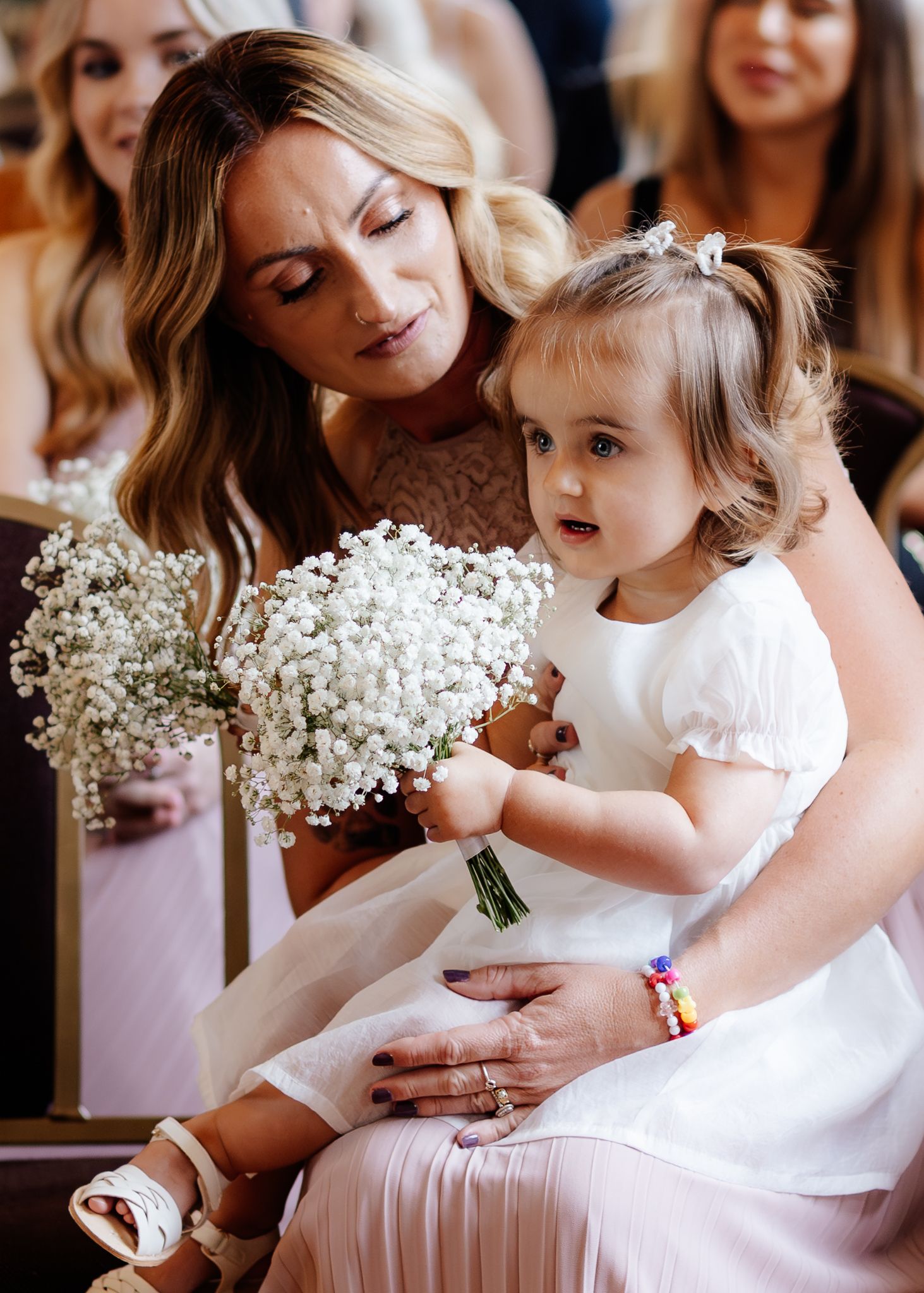 A tender moment captured in a series of photos showing a mother and daughter holding white baby's breath bouquets.