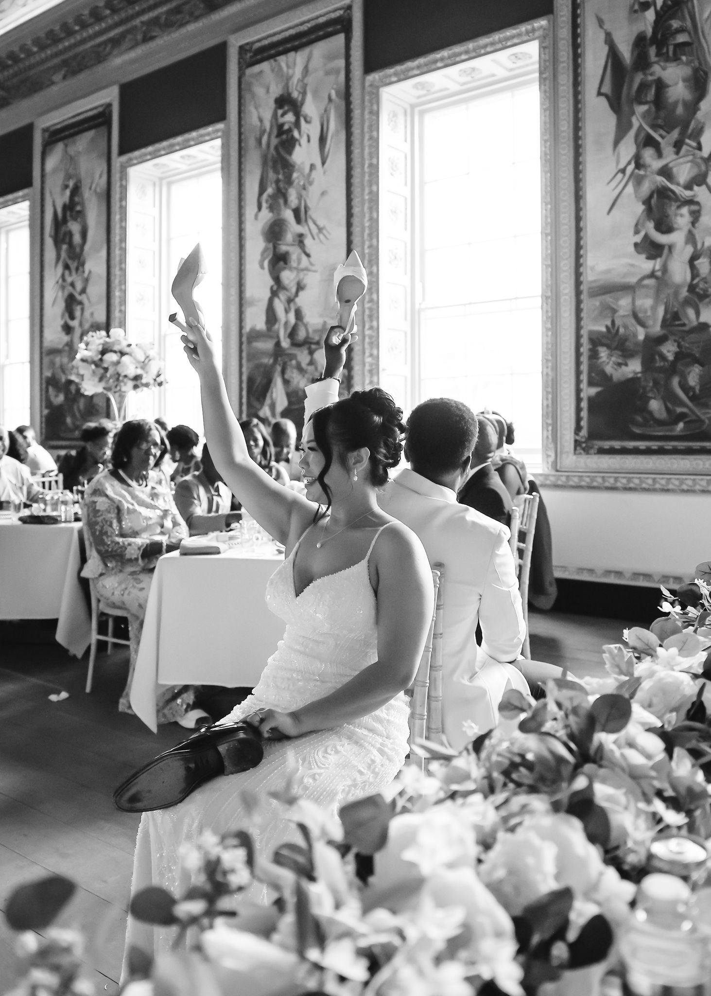 Wedding guests celebrate with raised hands and dance moves during a lively reception celebration.